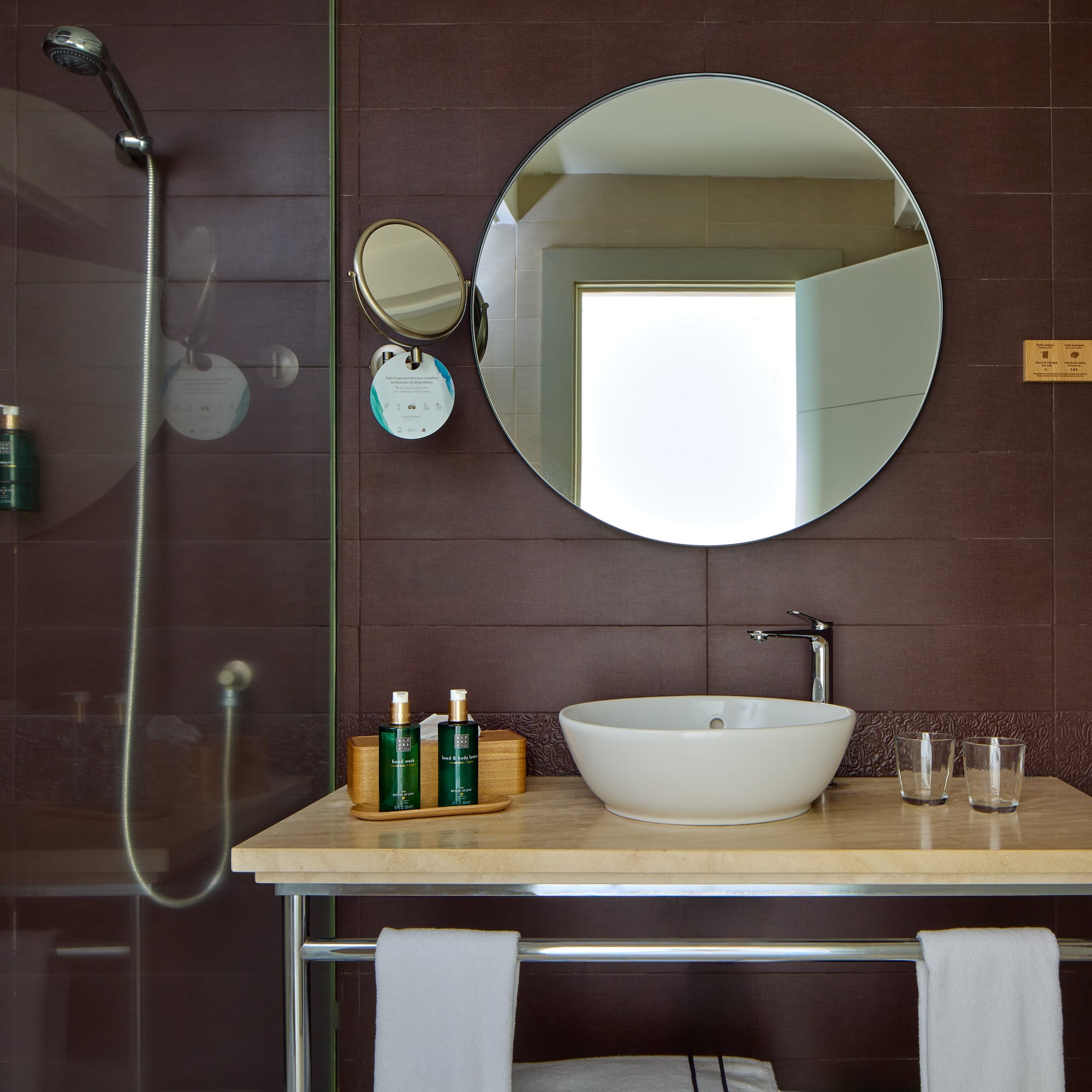 a bathroom with a round mirror and a sink