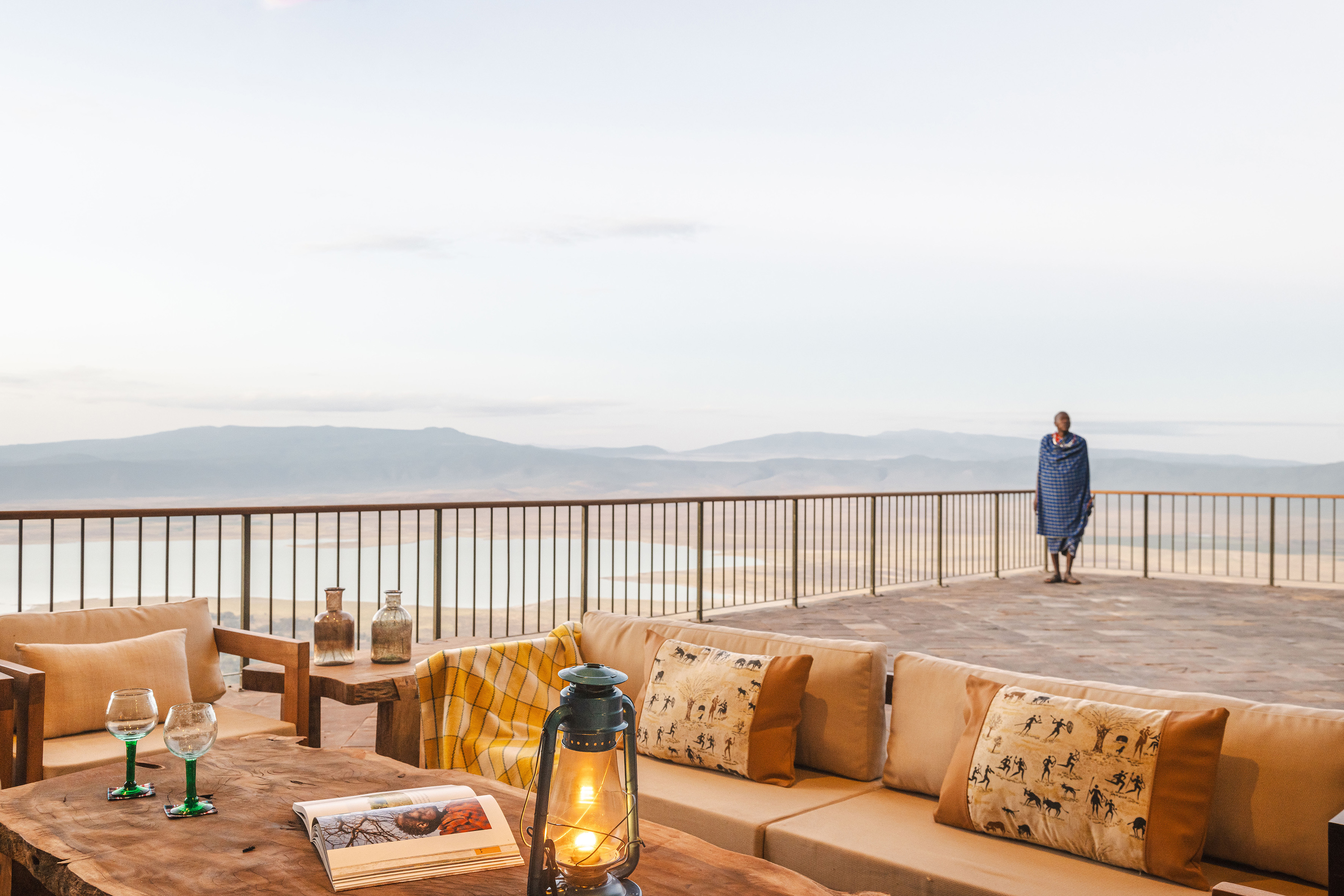 Maasai on safari lodge terrace overlooking Ngorongoro Crater landscape.