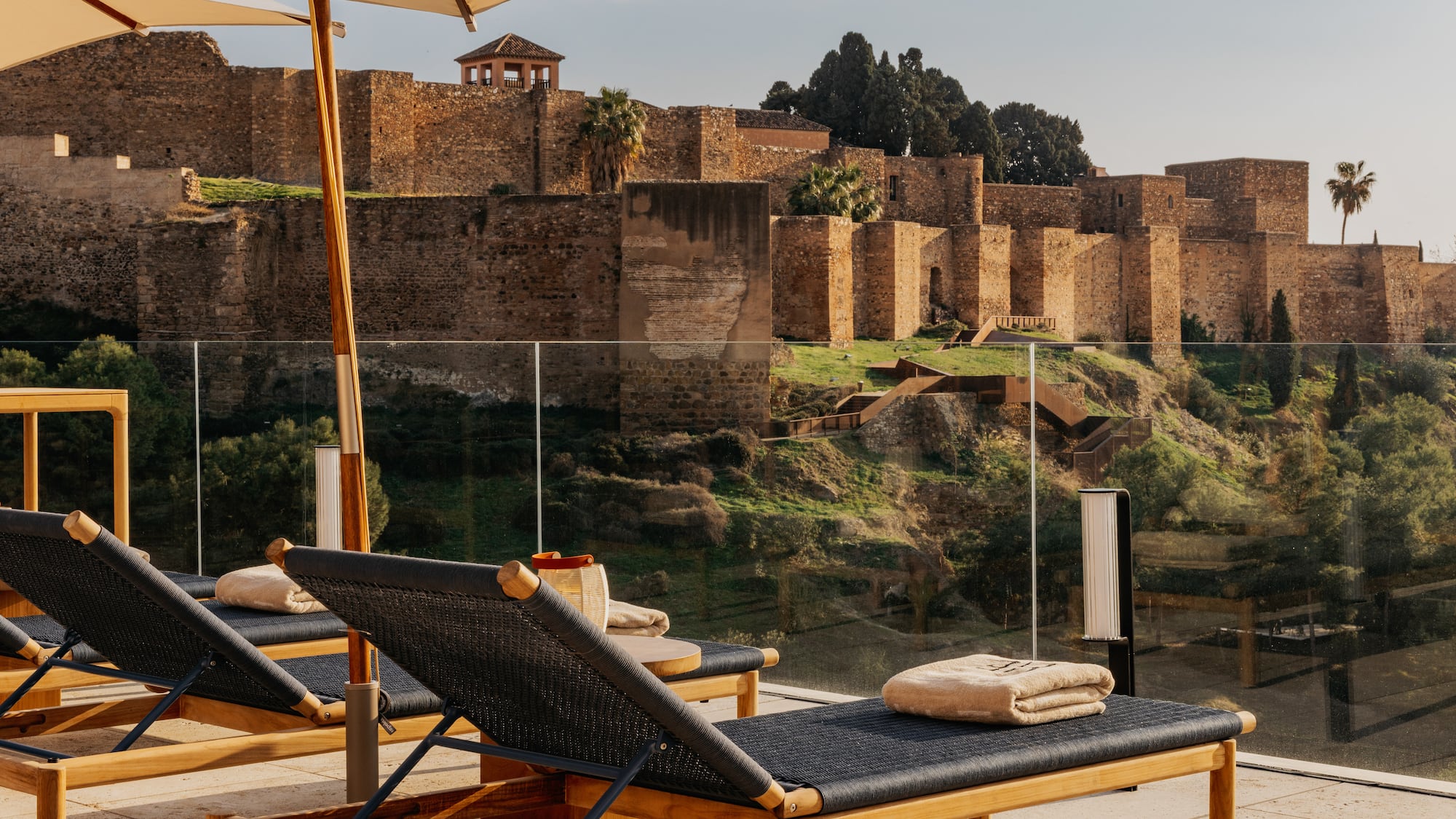Lounge chairs on sunny terrace overlooking Alcazaba fortress, Malaga.