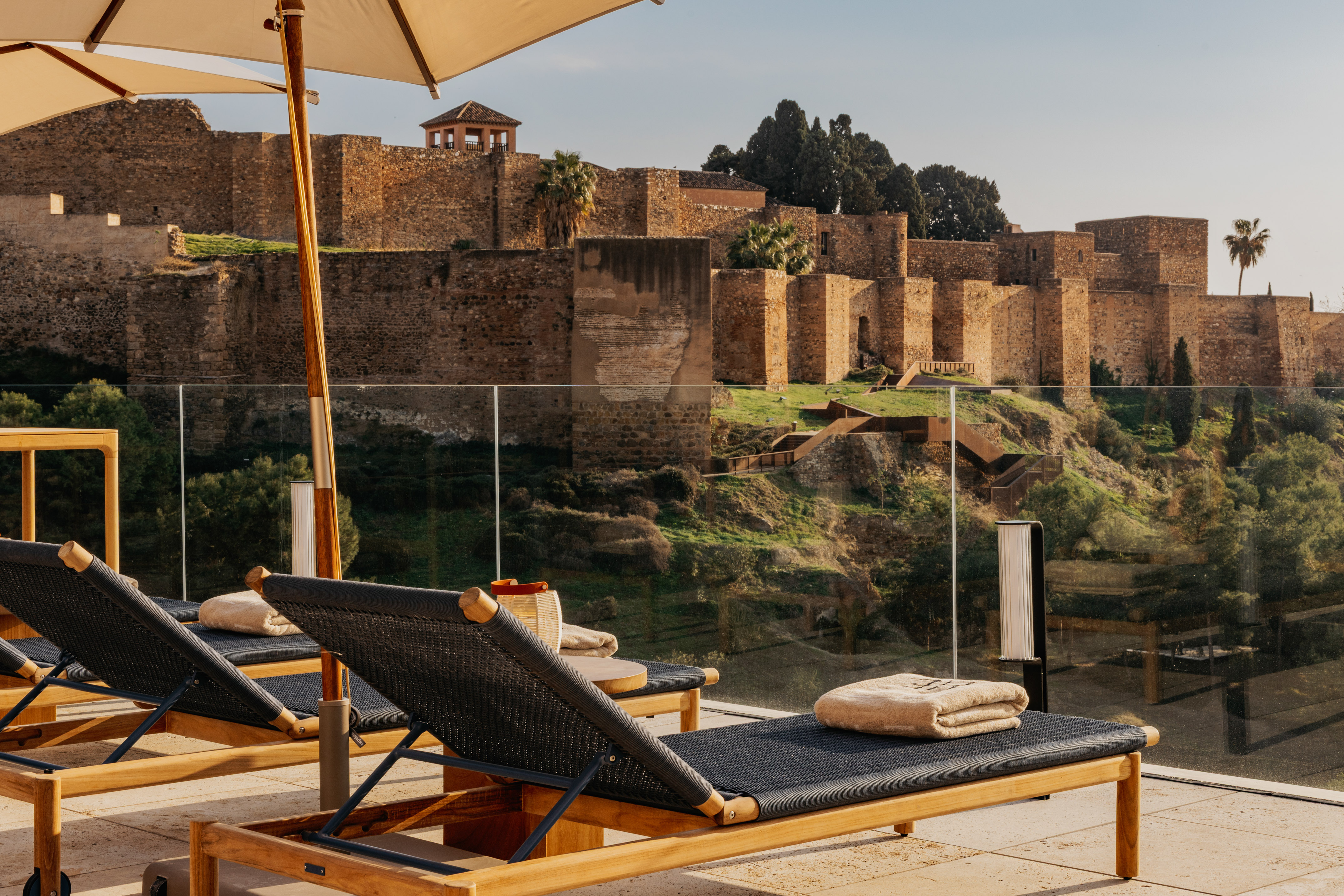 Lounge chairs on sunny terrace overlooking Alcazaba fortress, Malaga.
