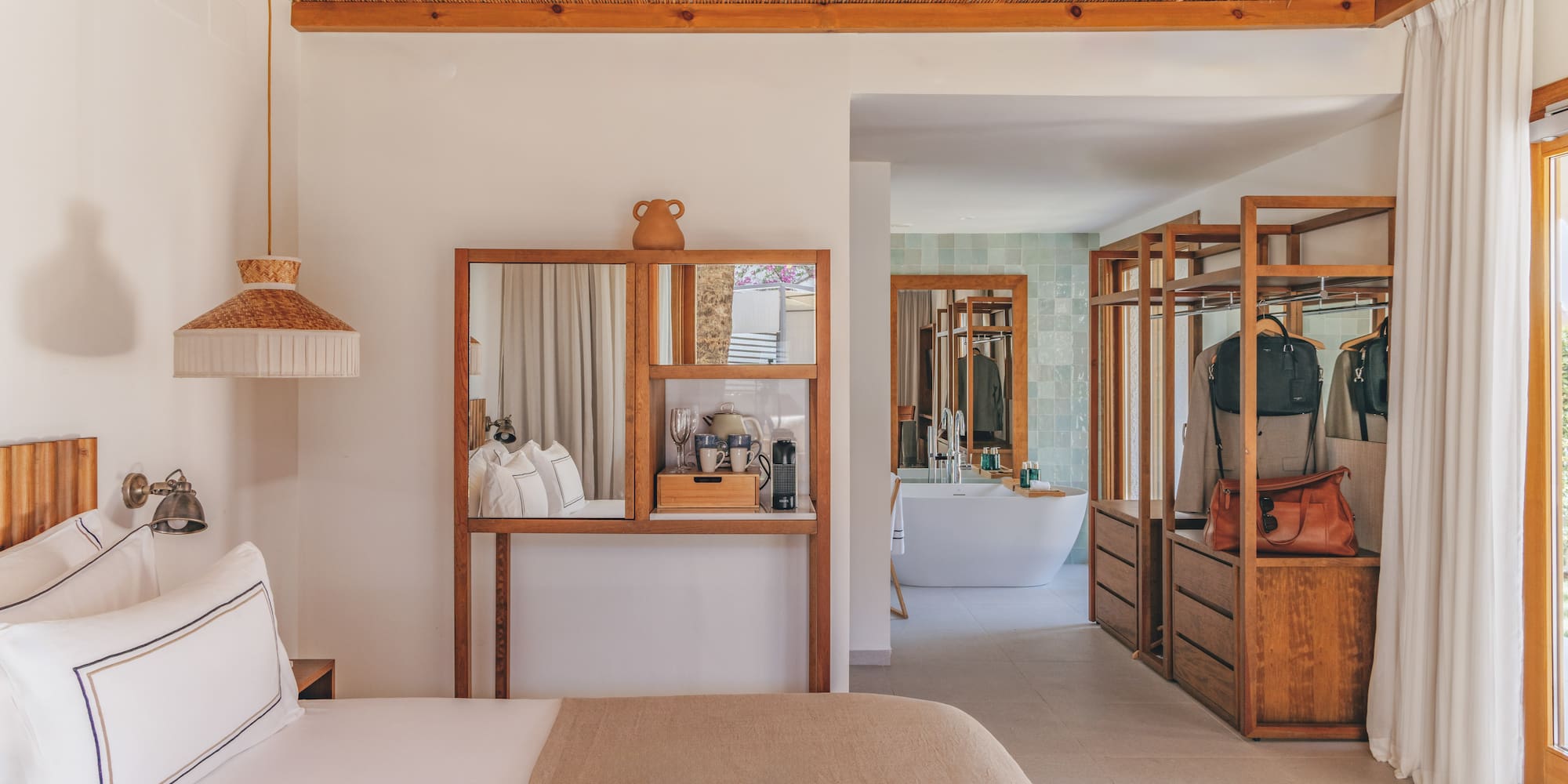 Modern hotel bedroom with open wood closet, bamboo ceiling, and bathroom.