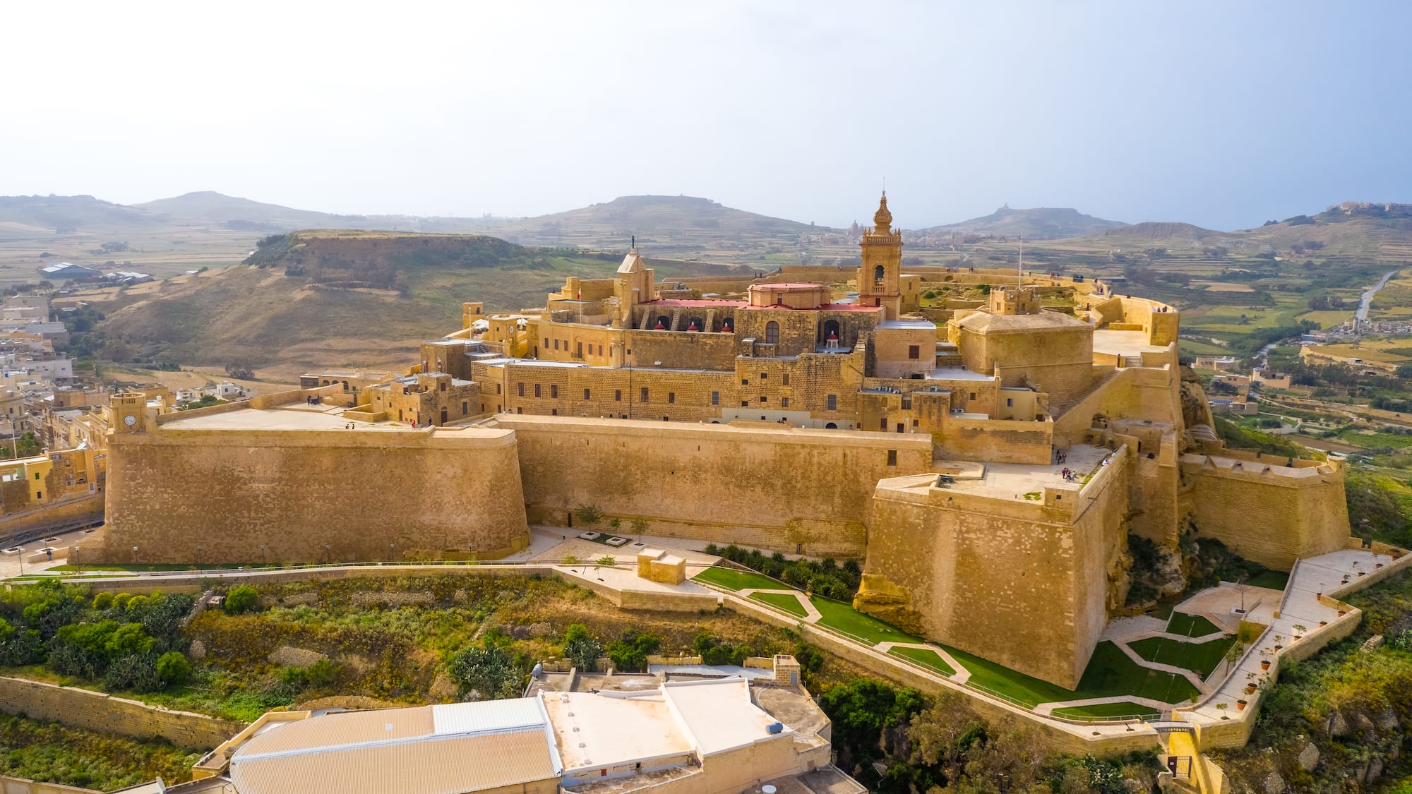 a large stone building with a tower and a large stone wall