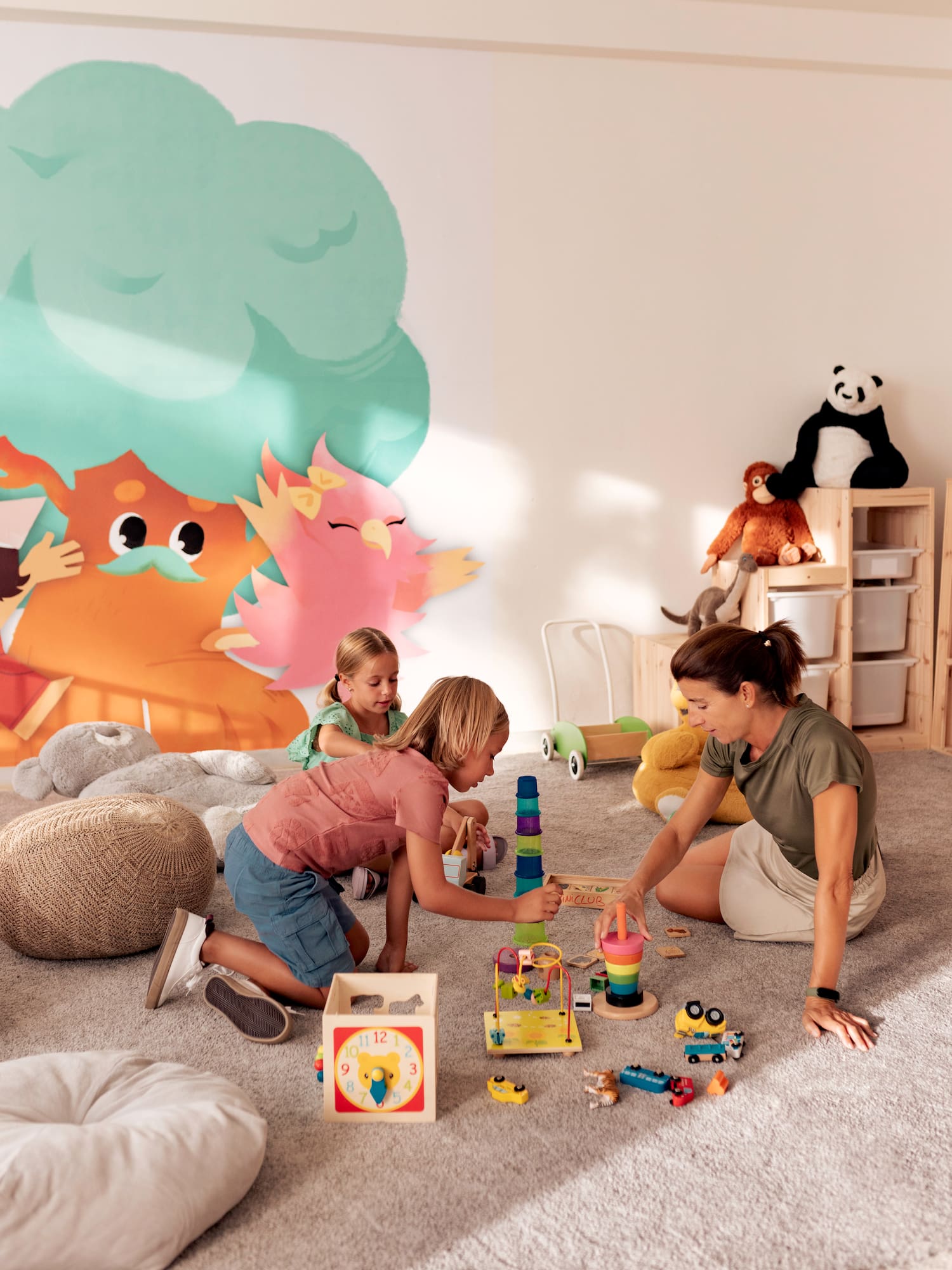 a woman and two girls playing with toys