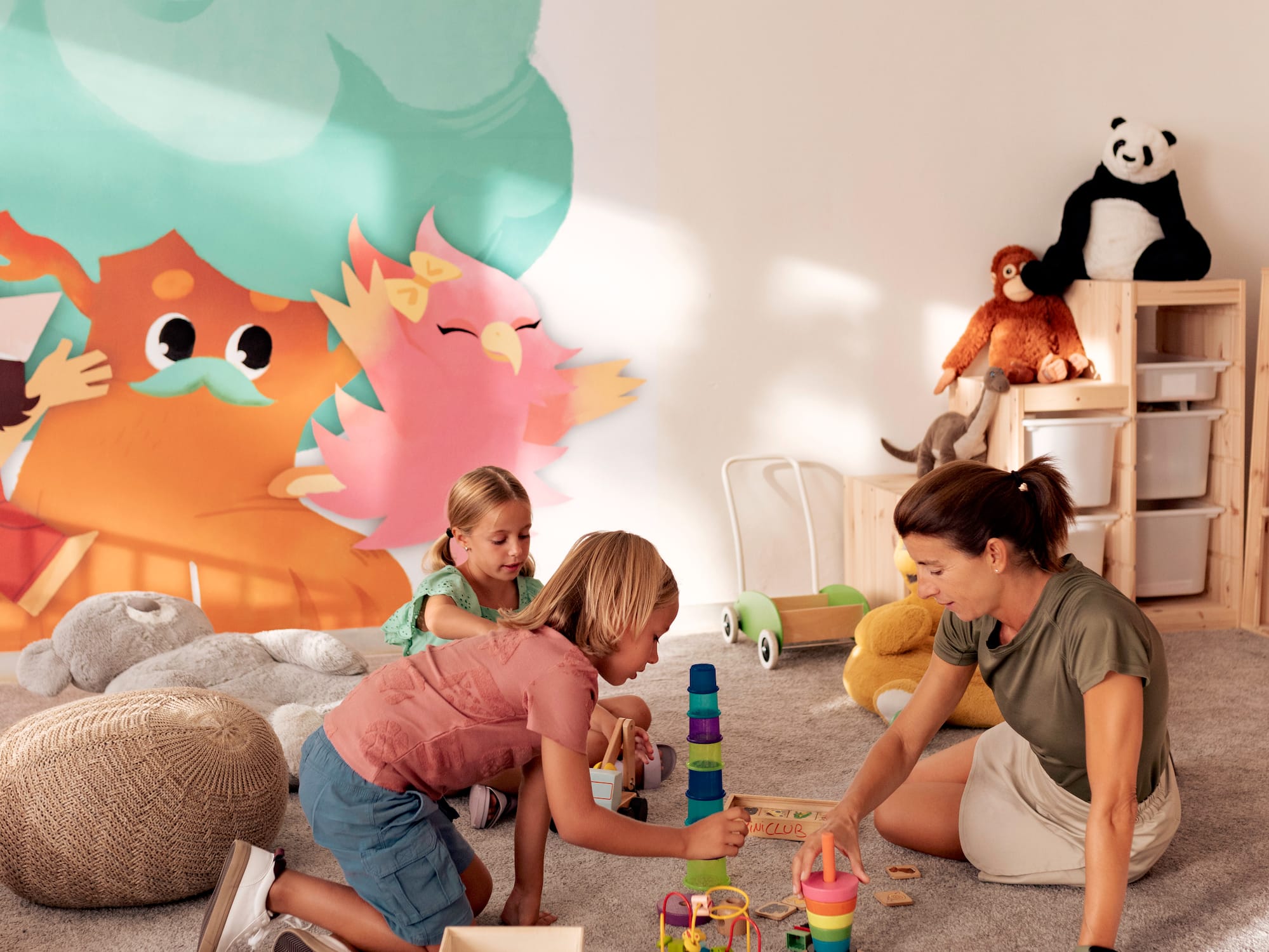 a woman and two girls playing with toys