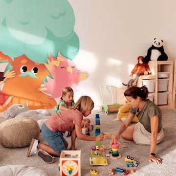 a woman and two girls playing with toys