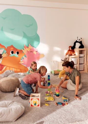 a woman and two girls playing with toys