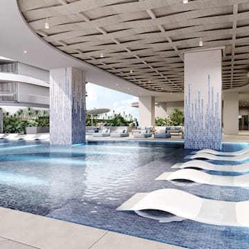 a pool with lounge chairs in a building