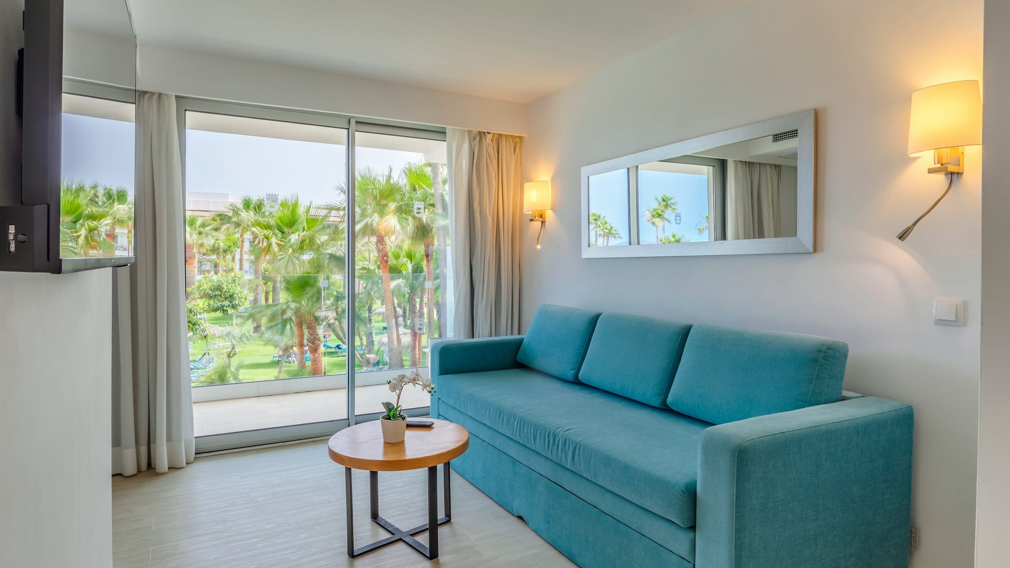 a blue couch in a room with a table and a mirror
