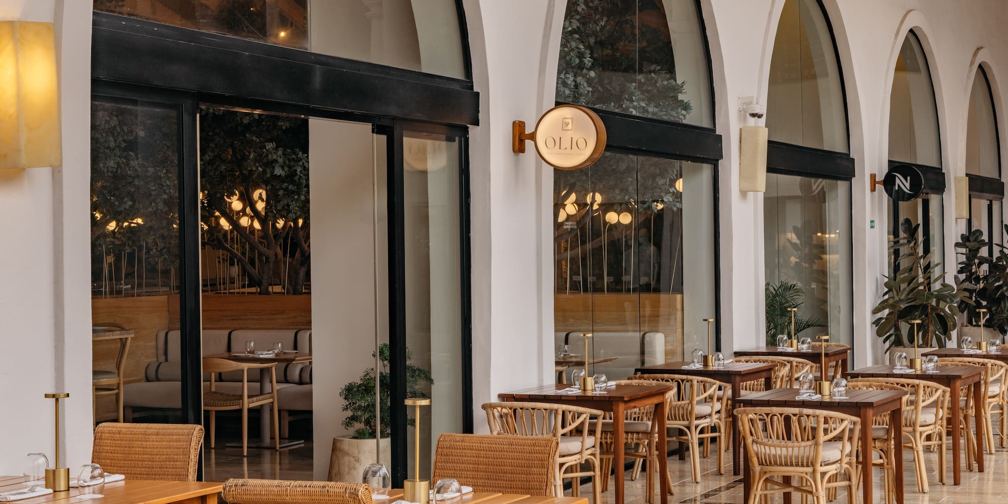 Olio Mediterranean restaurant outdoor patio with rattan chairs and tables.