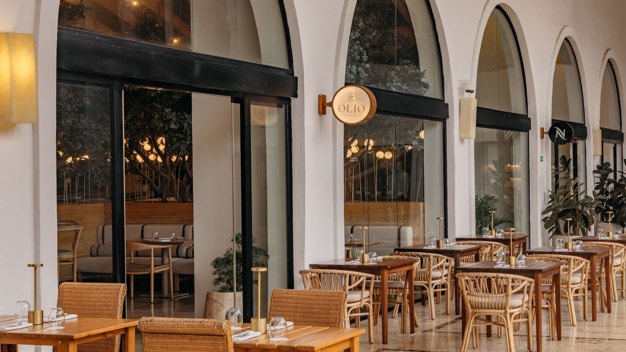 Olio Mediterranean restaurant outdoor patio with rattan chairs and tables.