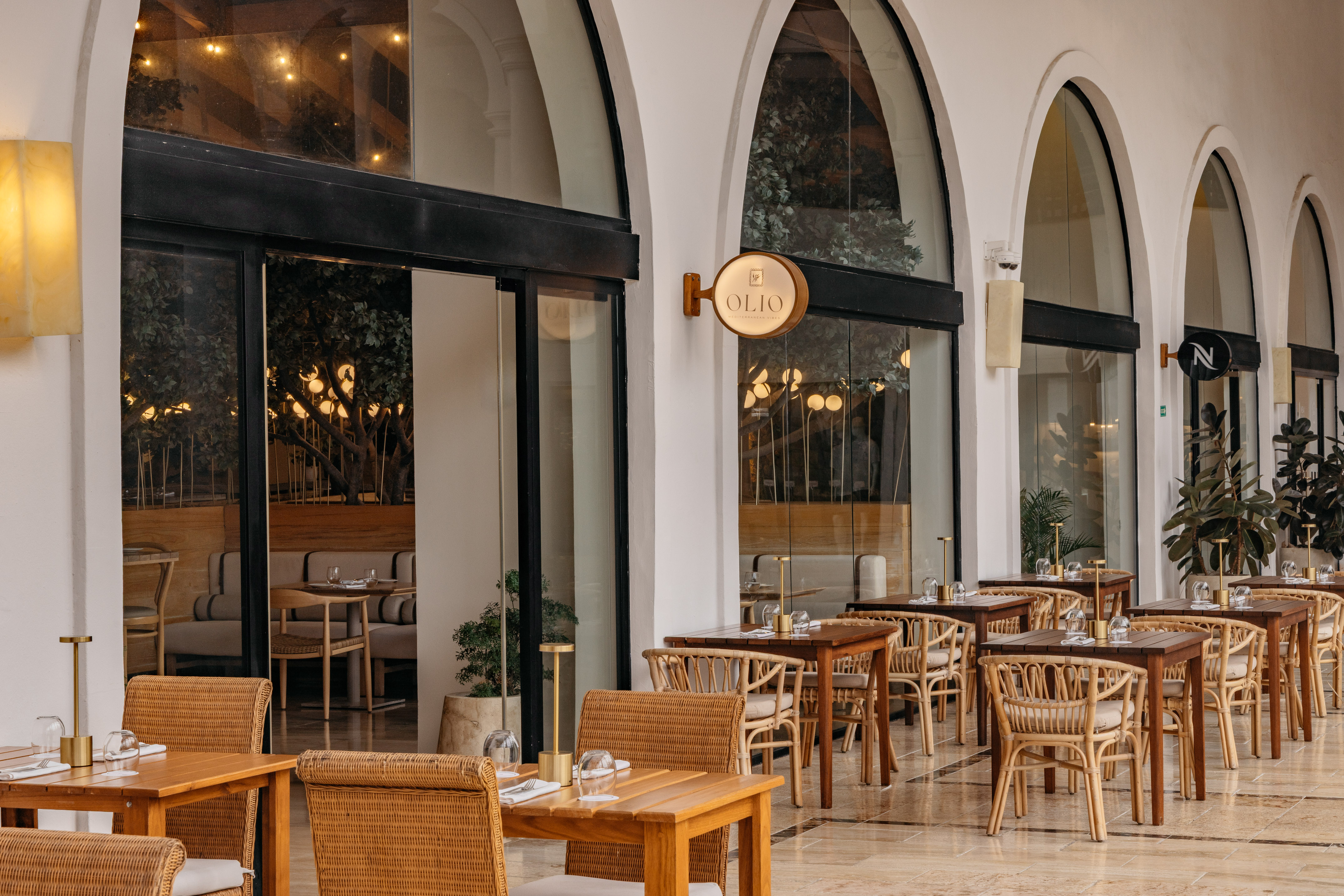 Olio Mediterranean restaurant outdoor patio with rattan chairs and tables.