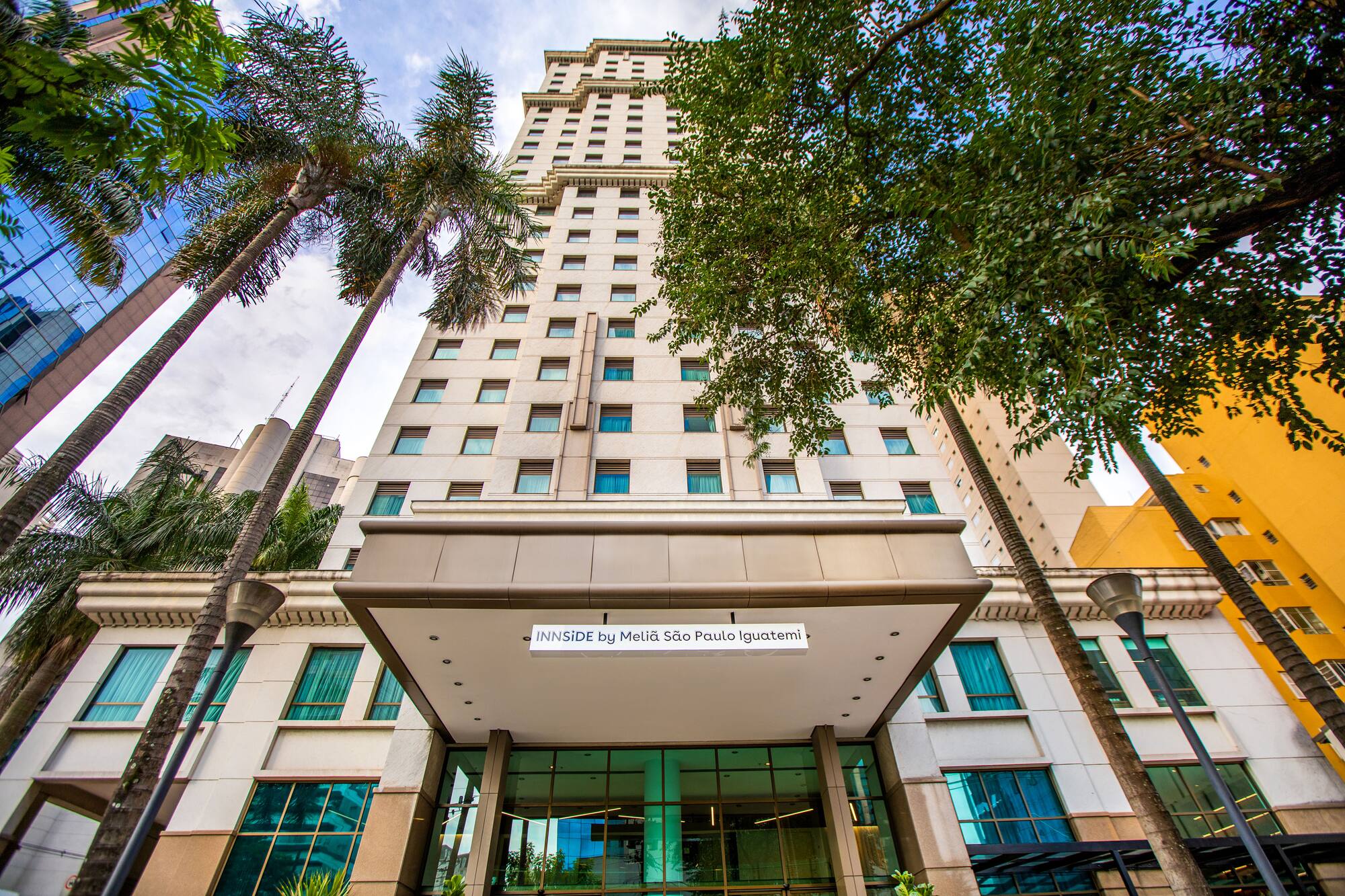 Modern INNSIDE by Meliá São Paulo Iguatemi hotel entrance with tall palm trees.