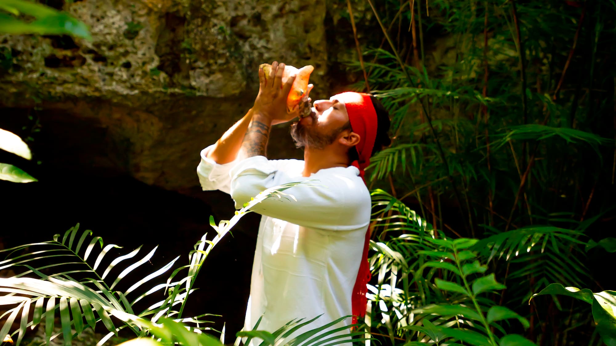 a man drinking from a bottle in the woods