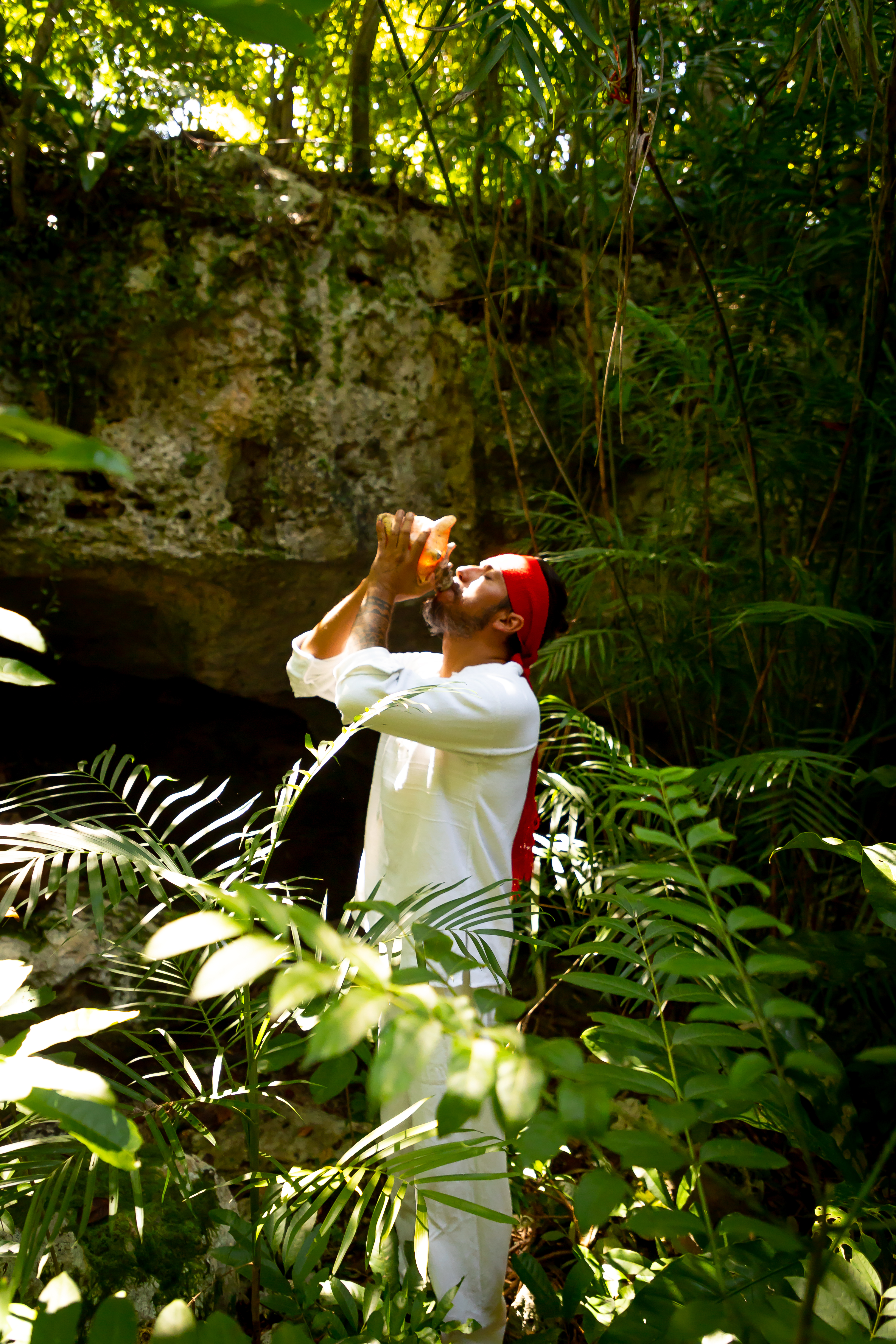 a man drinking from a bottle in the woods
