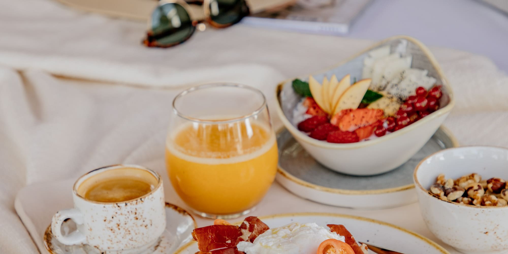 a plate of food and drinks on a bed