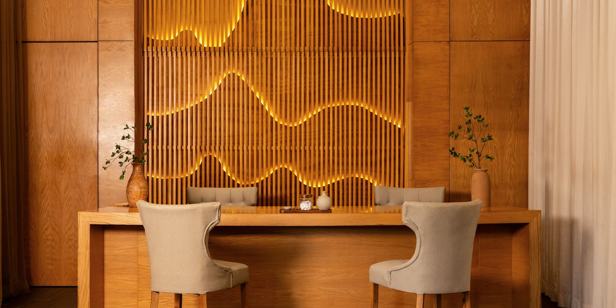 Contemporary wooden reception area with wavy illuminated slat wall.
