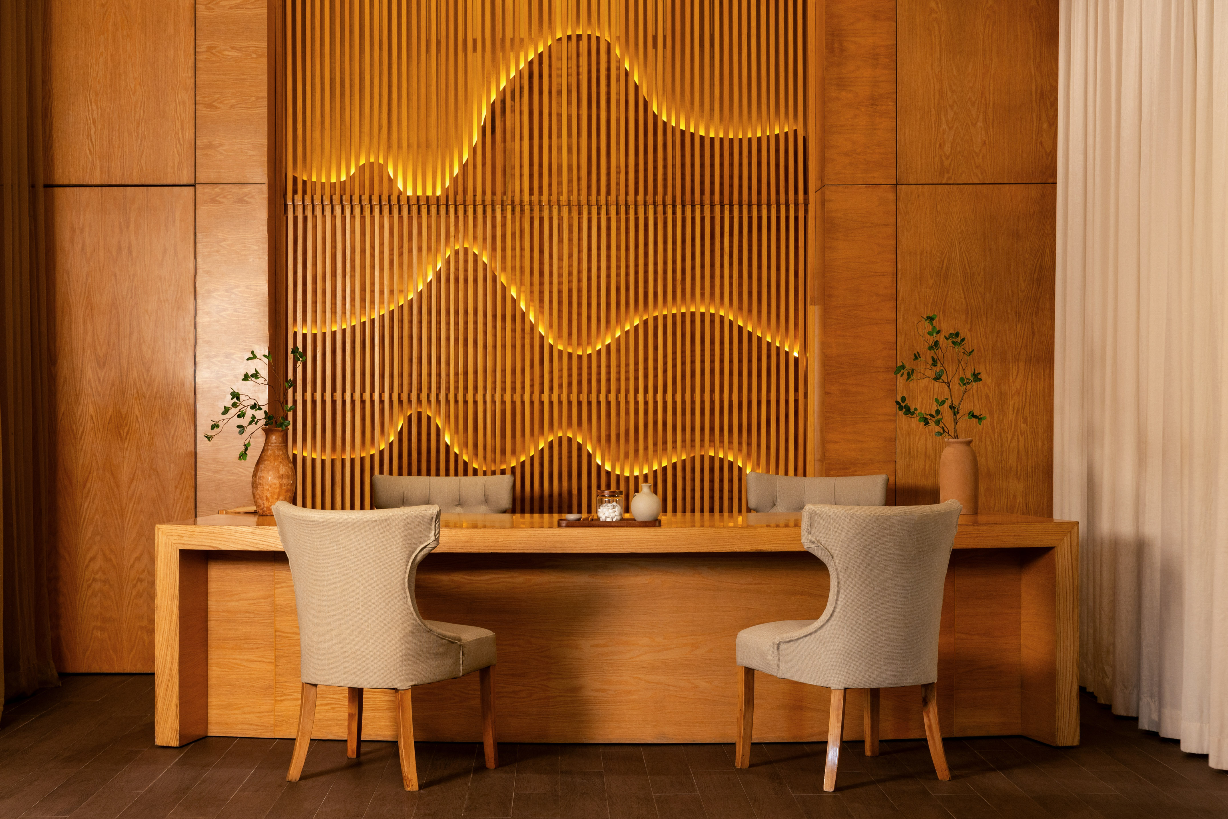 Contemporary wooden reception area with wavy illuminated slat wall.