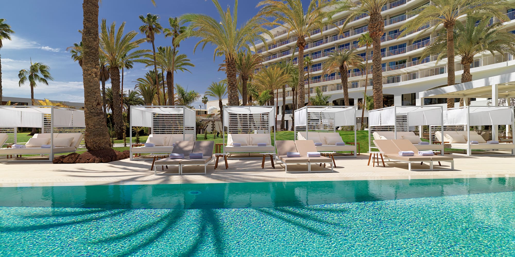 a pool with lounge chairs and palm trees