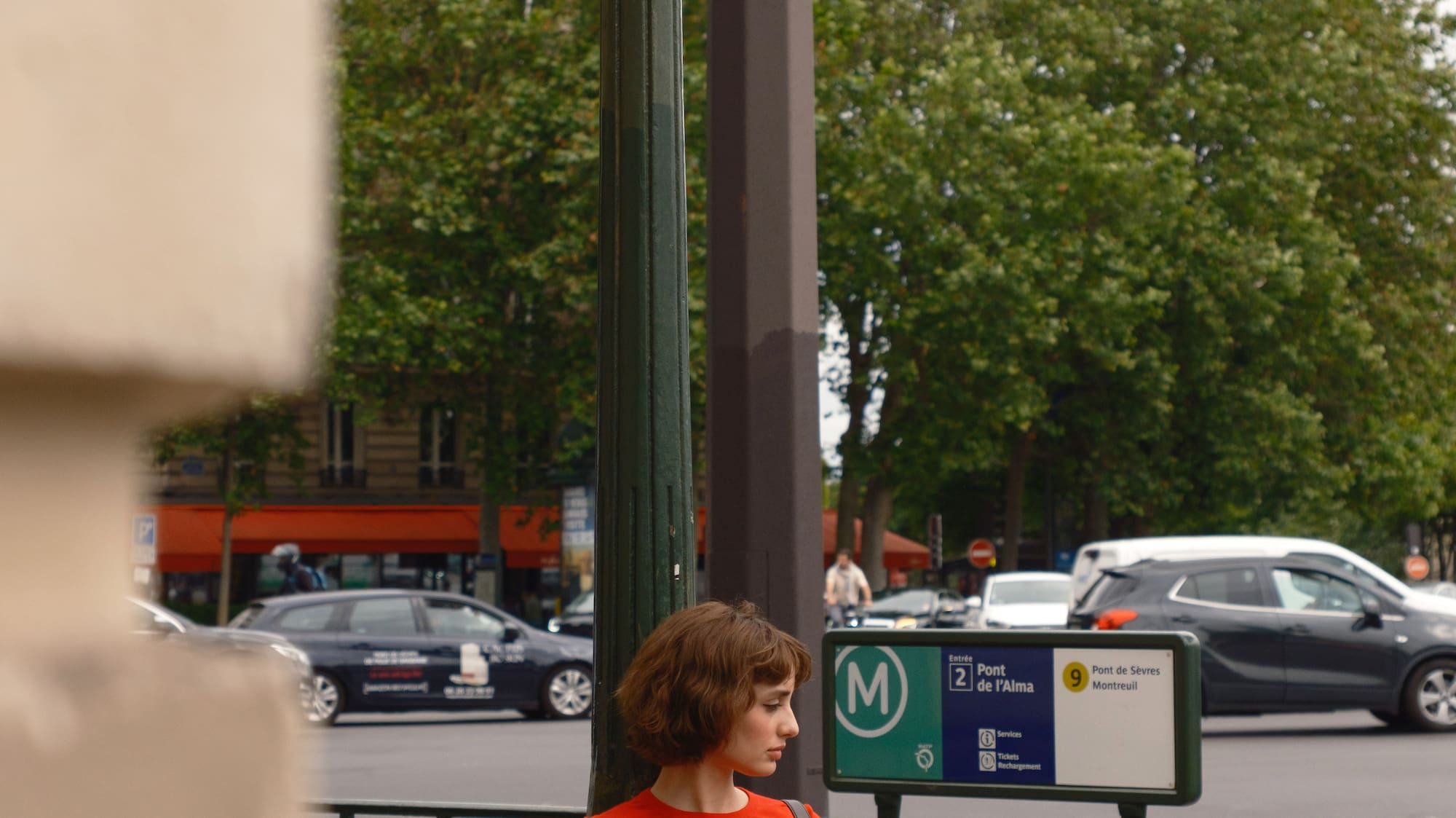 a woman standing on a sidewalk holding a newspaper