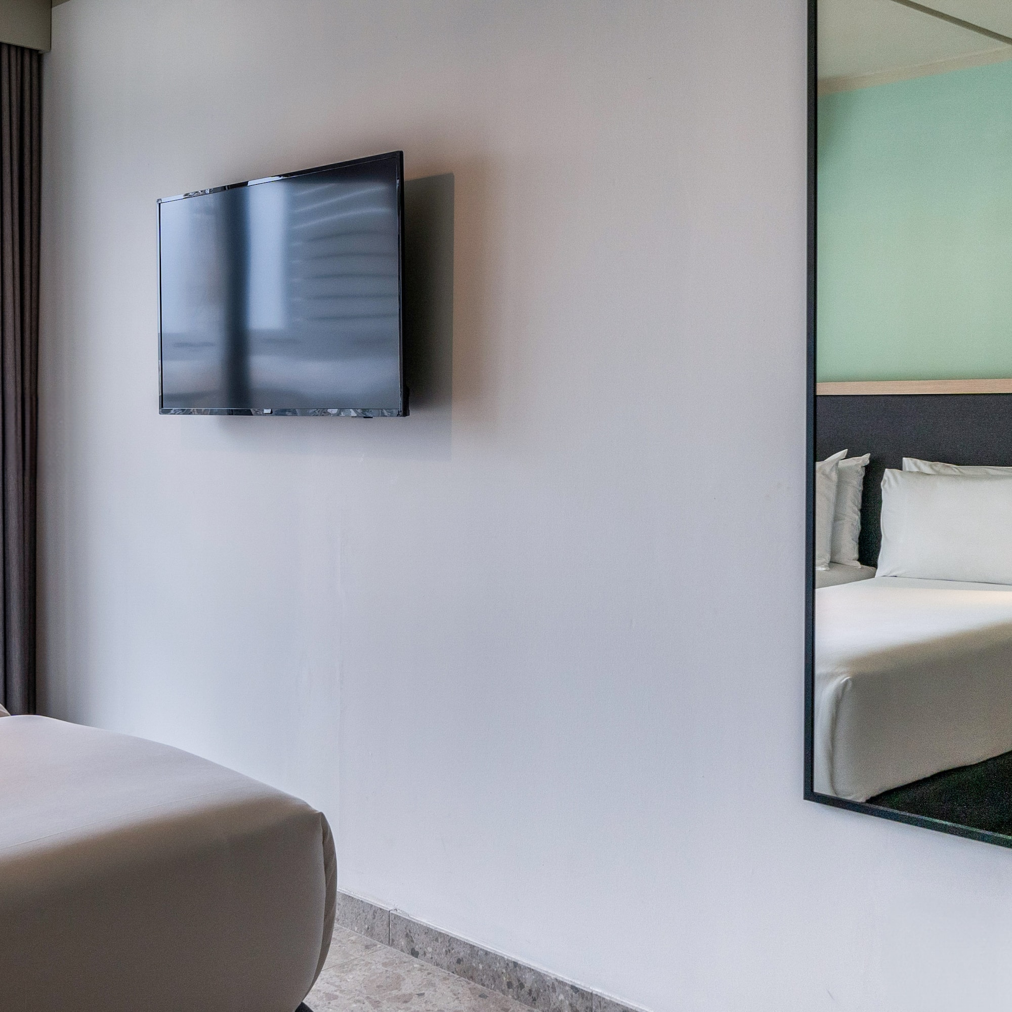 a mirror on the wall next to a bed