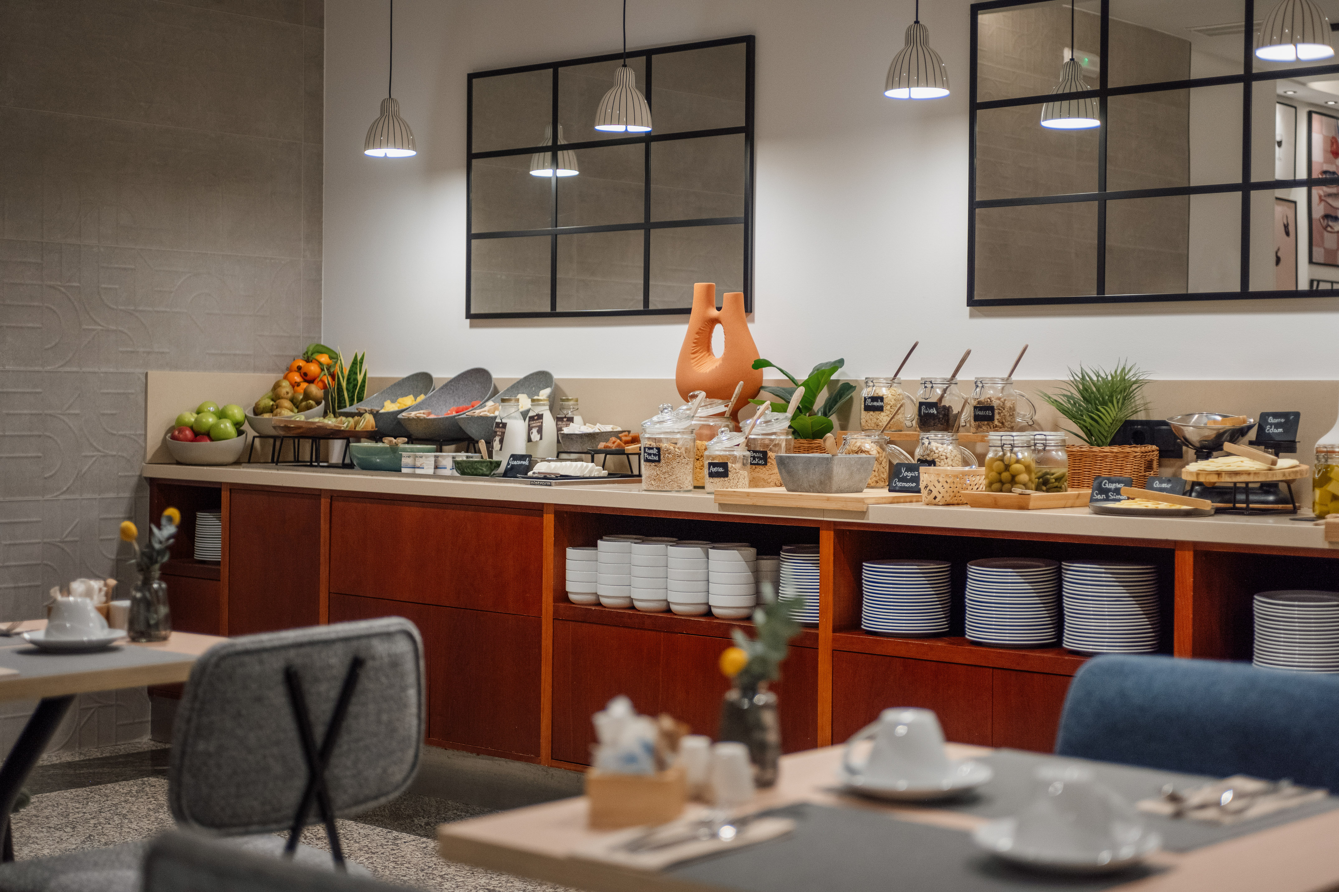 Modern hotel breakfast buffet with fresh fruits, cereals, yogurt, and cheese.