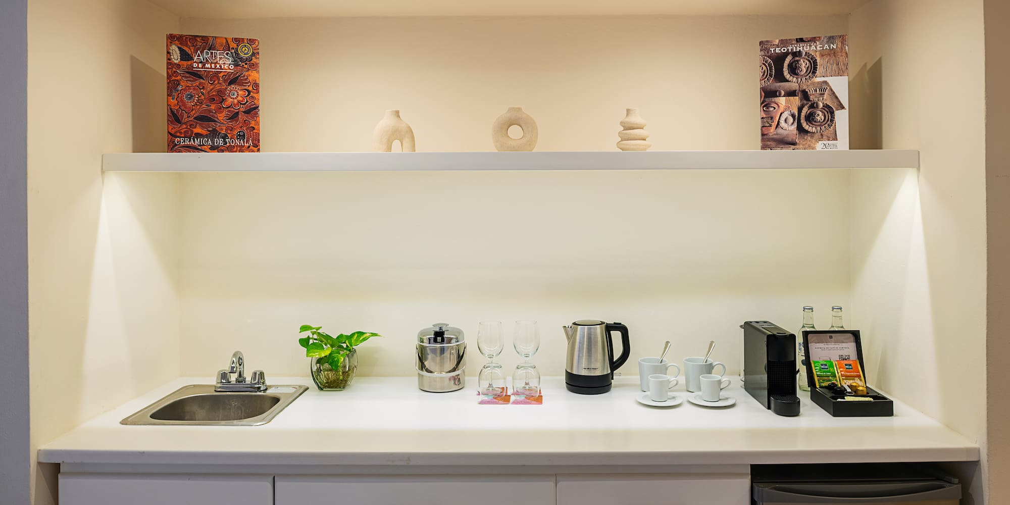 a kitchen counter with white cabinets and white shelves