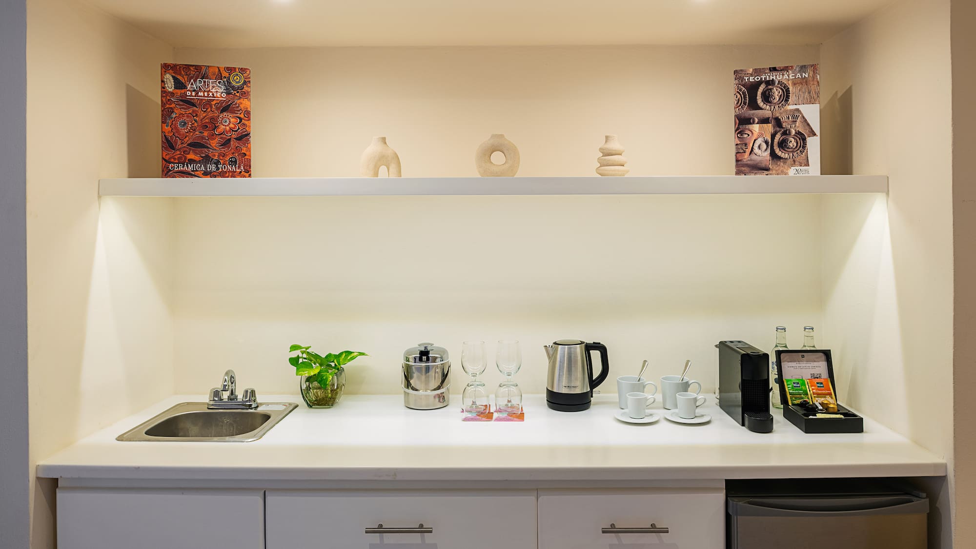 a kitchen counter with white cabinets and white shelves