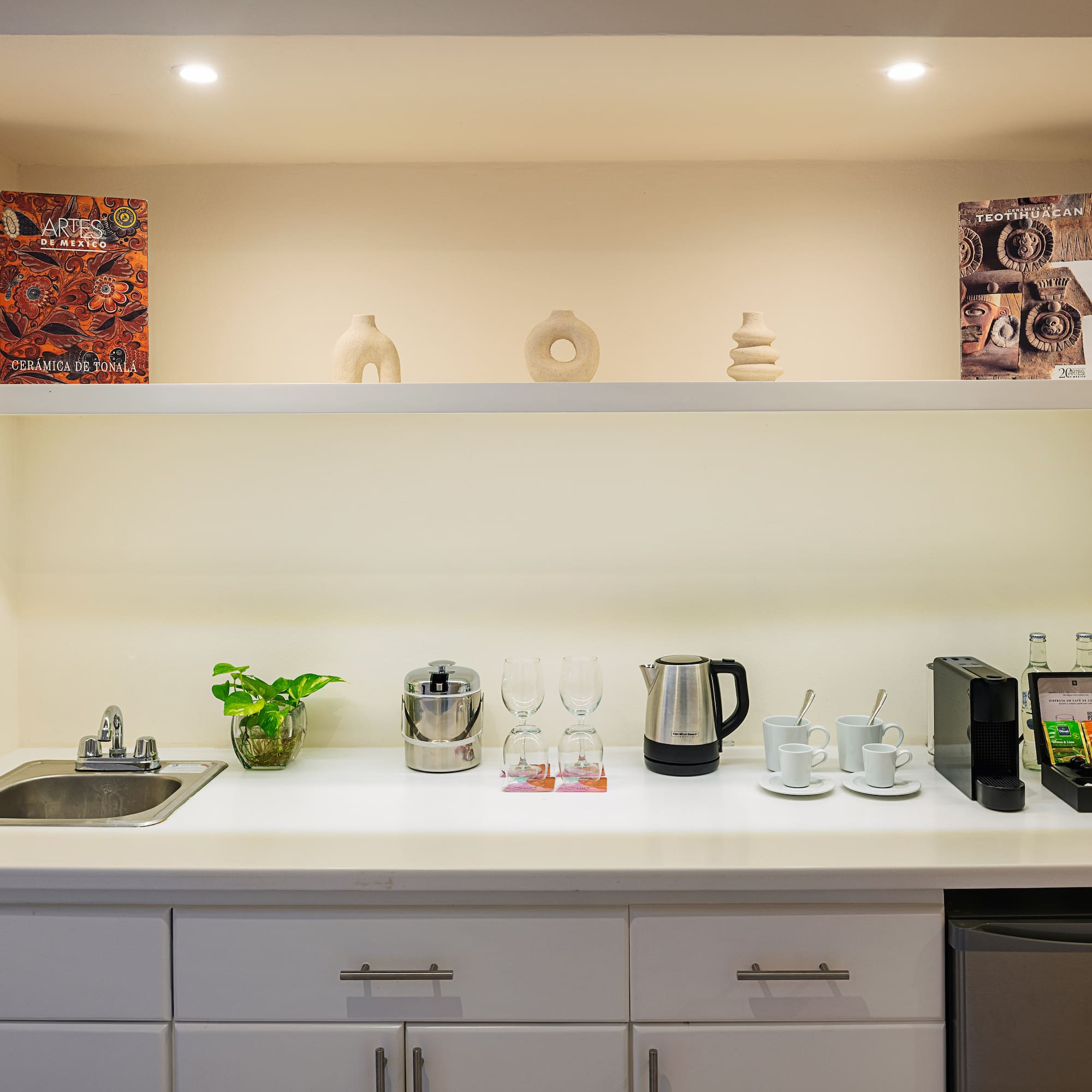 a kitchen counter with white cabinets and white shelves