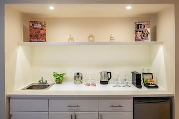 a kitchen counter with white cabinets and white shelves