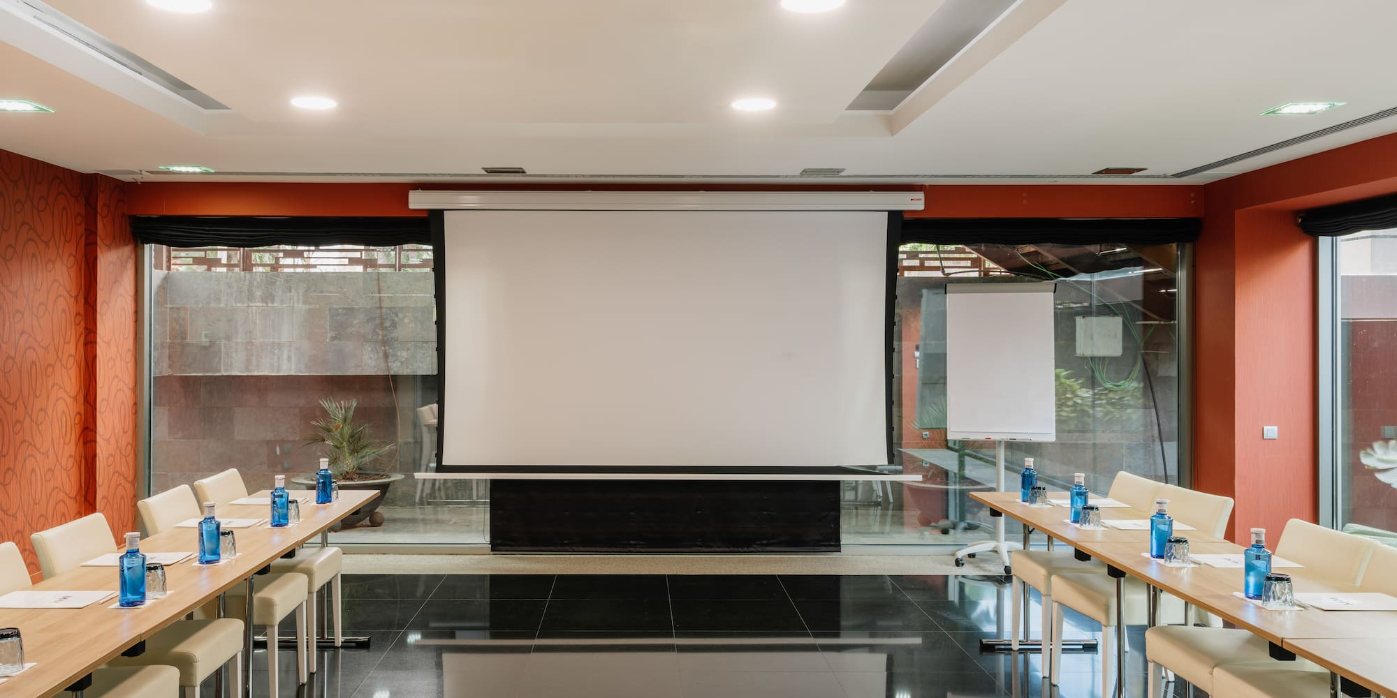 a room with a projector screen and tables