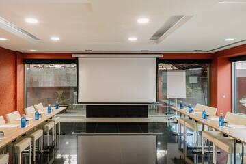 a room with a projector screen and tables