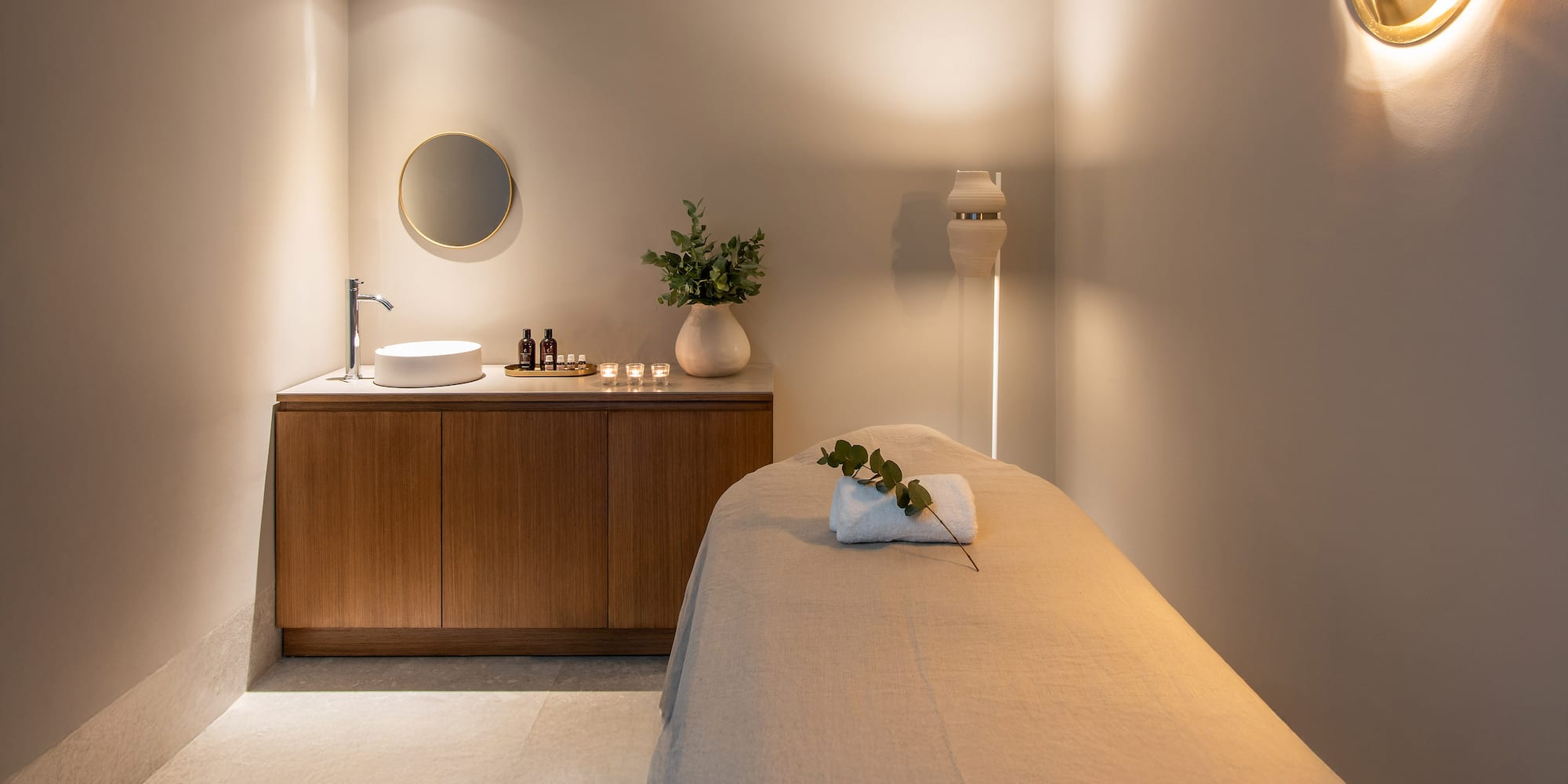 a massage room with a sink and a bed