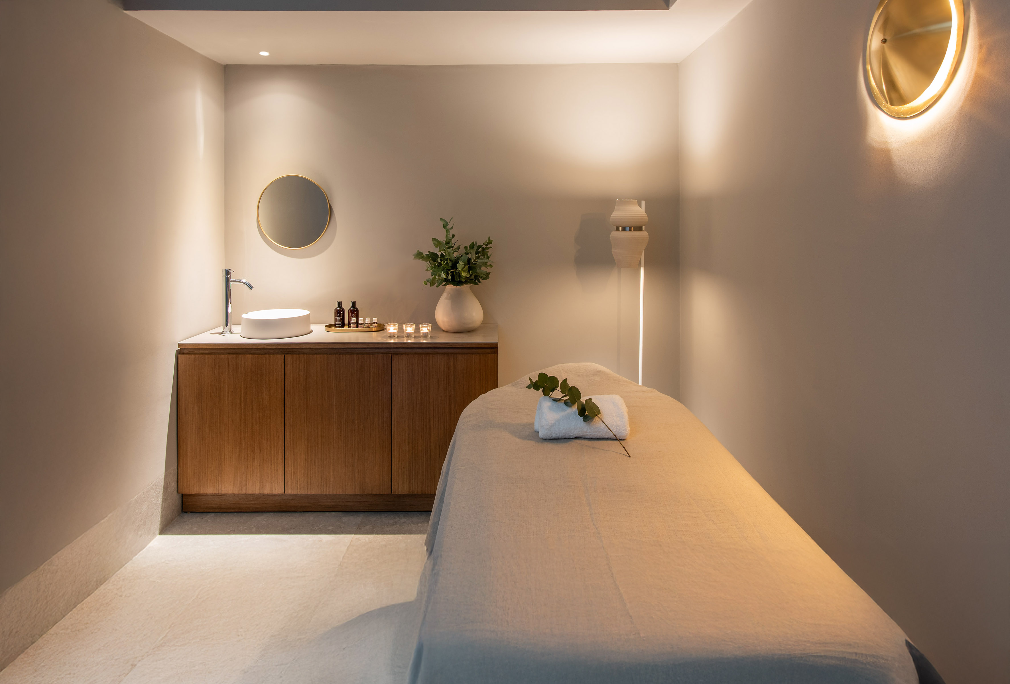 a massage room with a sink and a bed