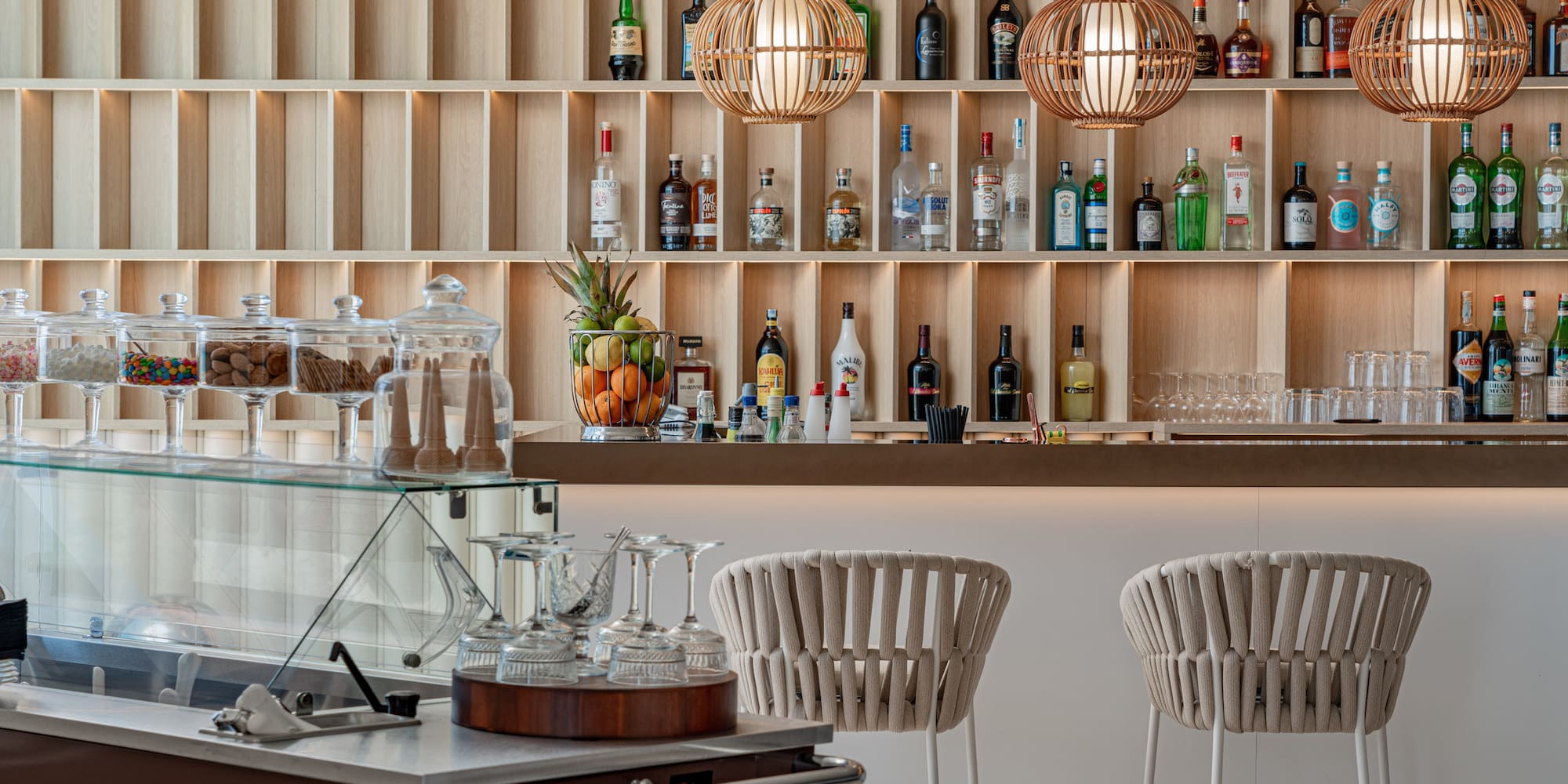a bar with shelves of liquor bottles and glasses
