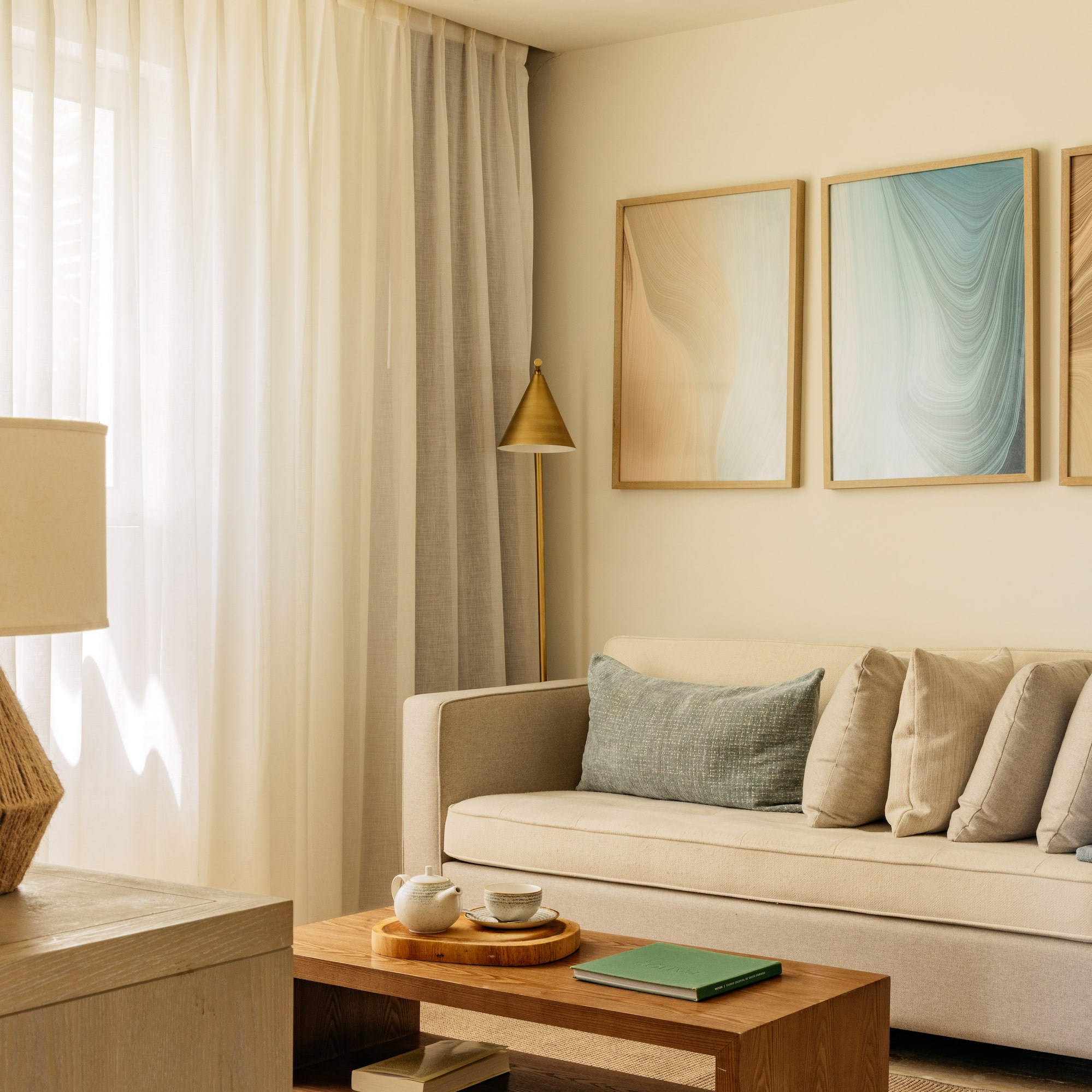 Modern living room with beige sofa, abstract wall art, and neutral decor.