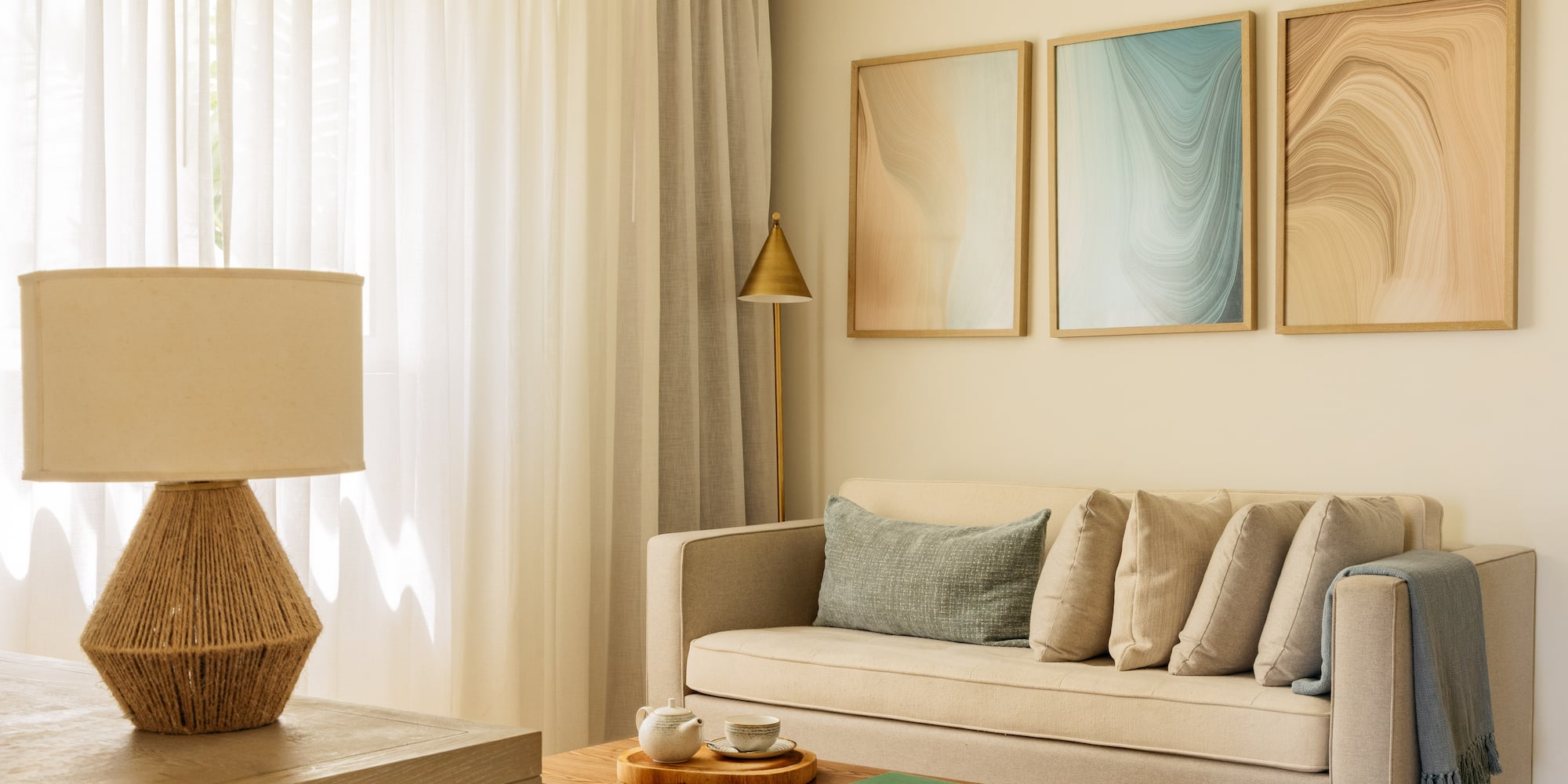 Modern living room with beige sofa, abstract wall art, and neutral decor.