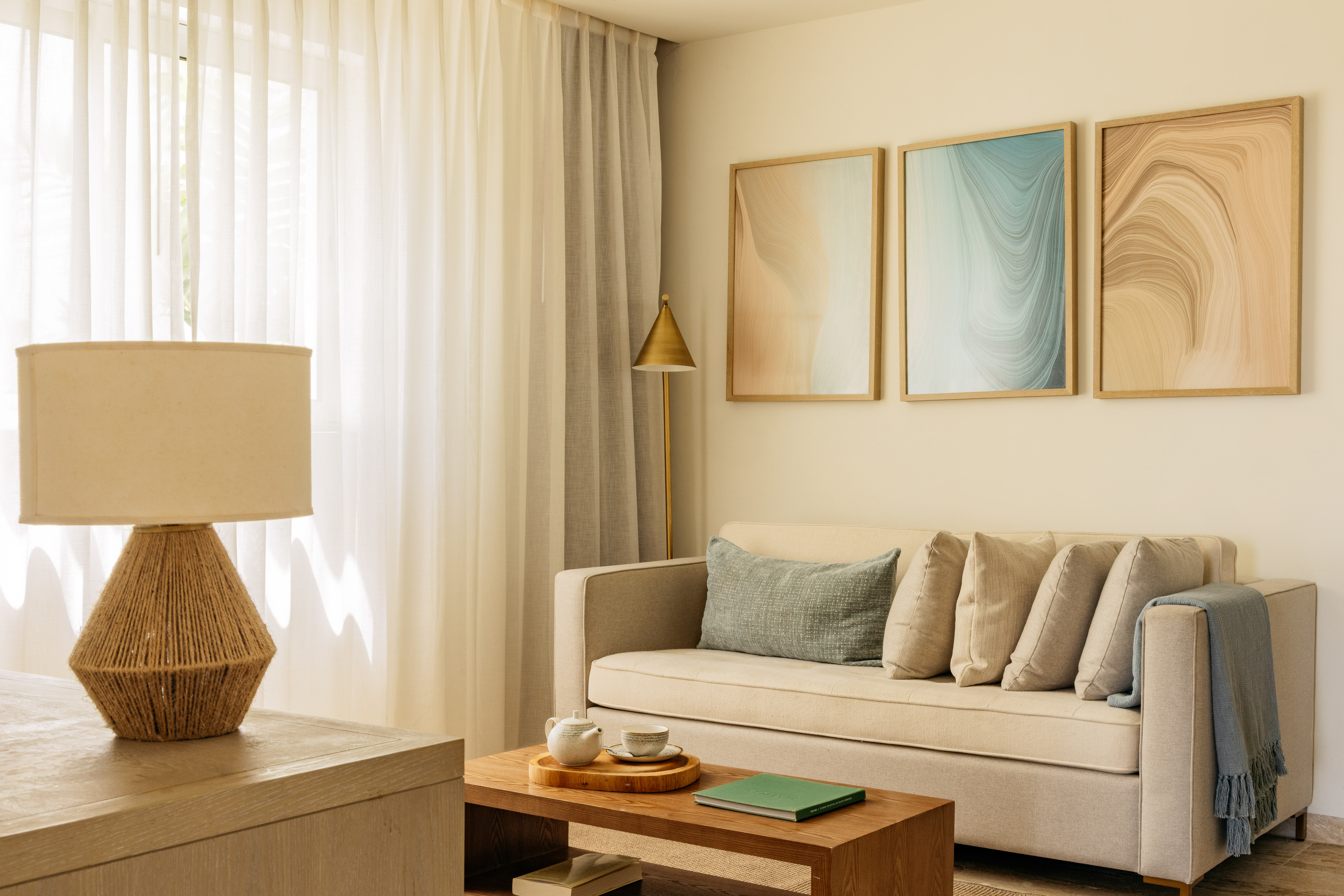Modern living room with beige sofa, abstract wall art, and neutral decor.