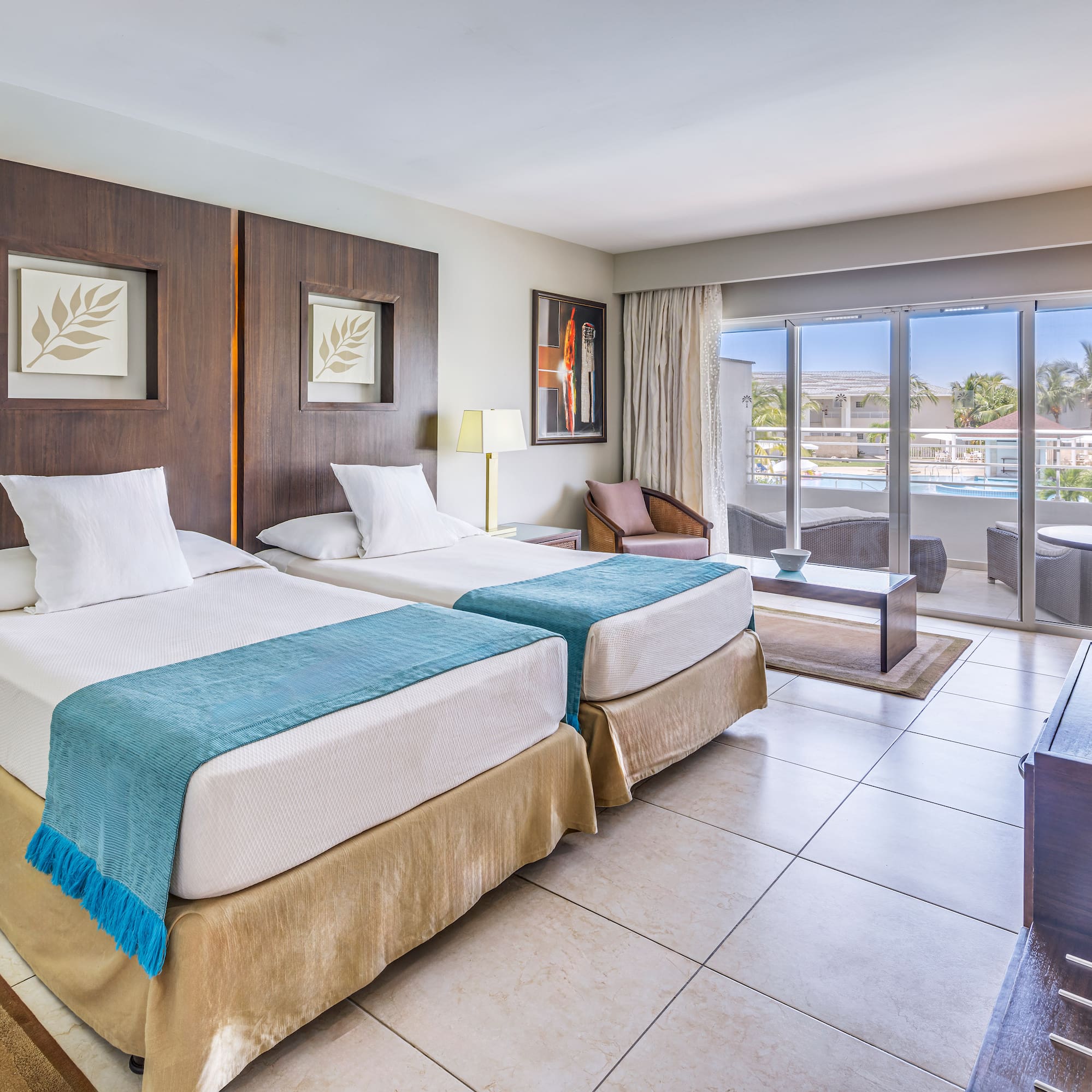 a room with two beds and a pool in the background