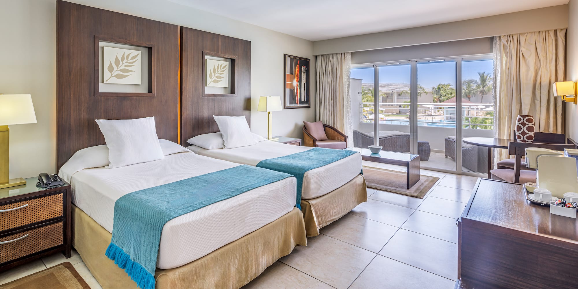 a room with two beds and a pool in the background