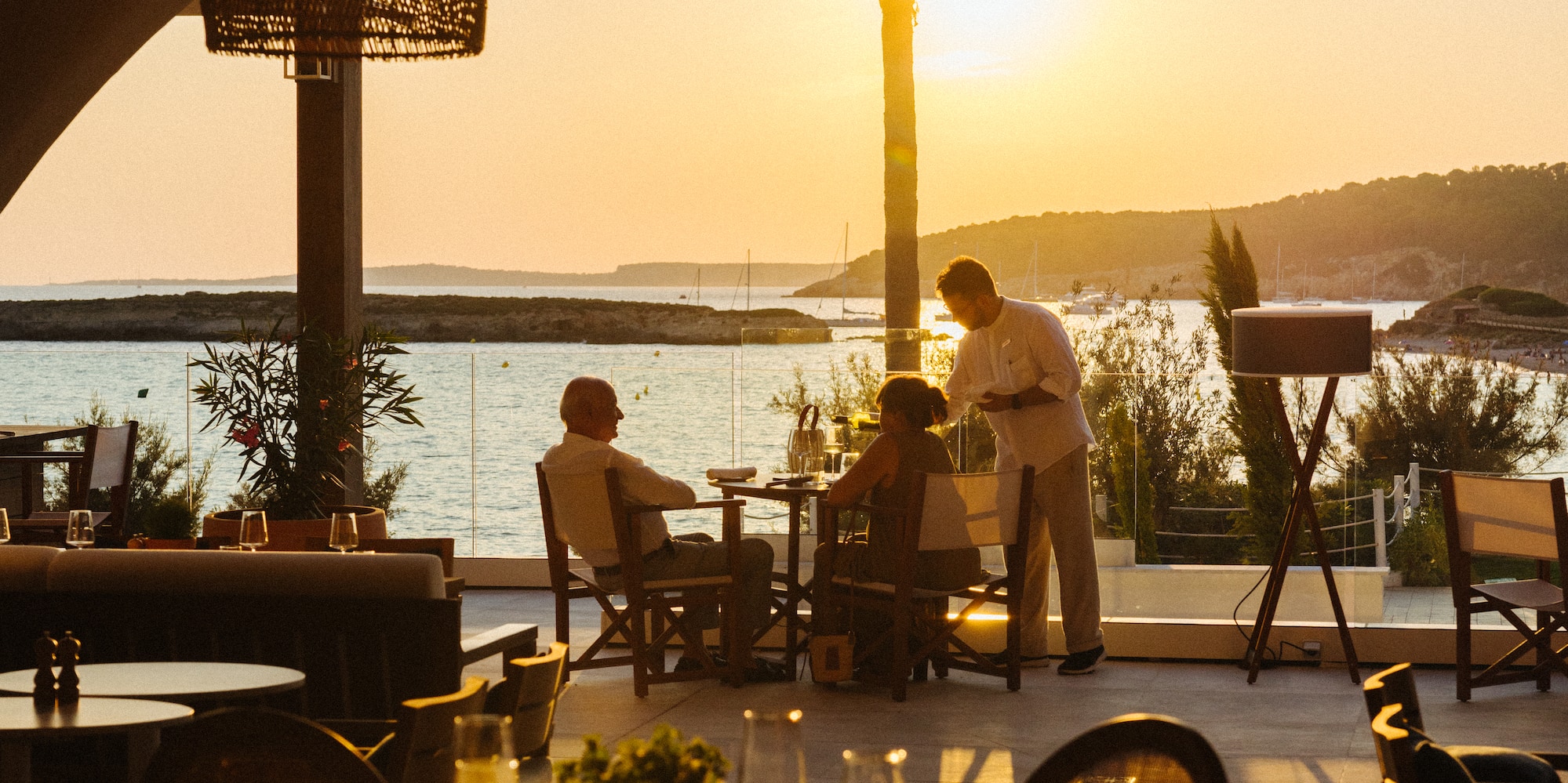 a group of people sitting at tables outside