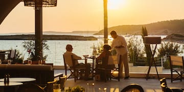 a group of people sitting at tables outside