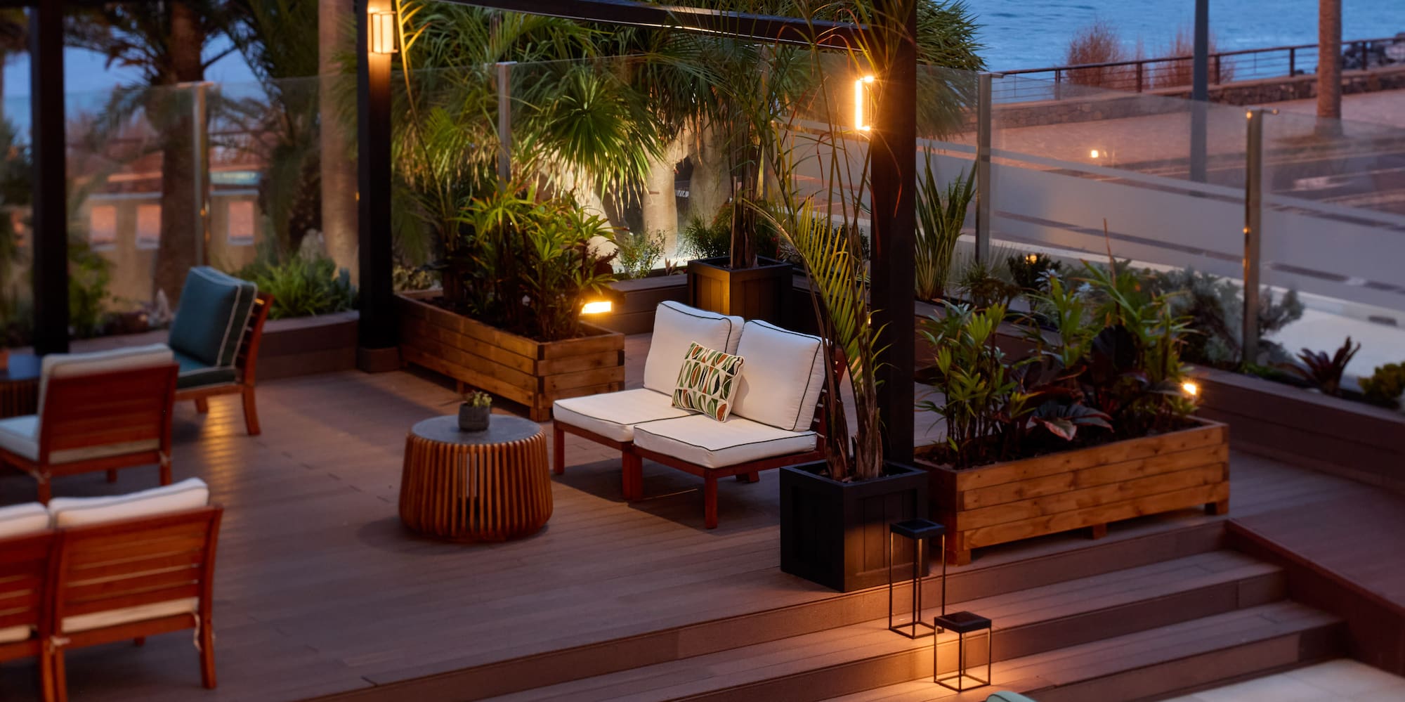 a patio with chairs and tables and a view of the ocean