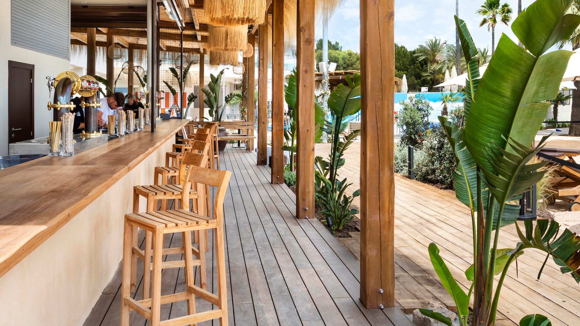 a wooden patio with chairs and a pool in the background