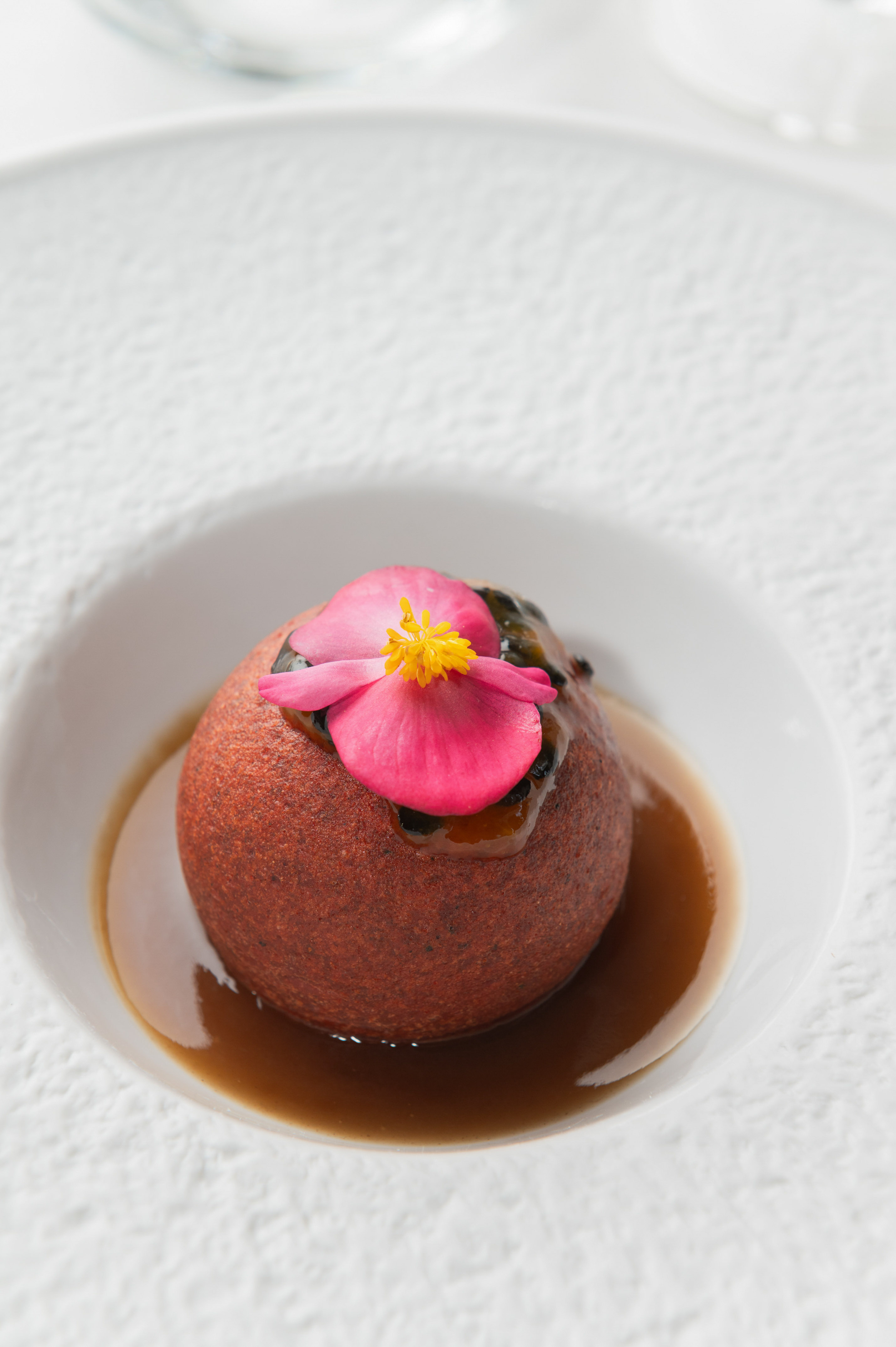 a round brown object with a pink flower on top