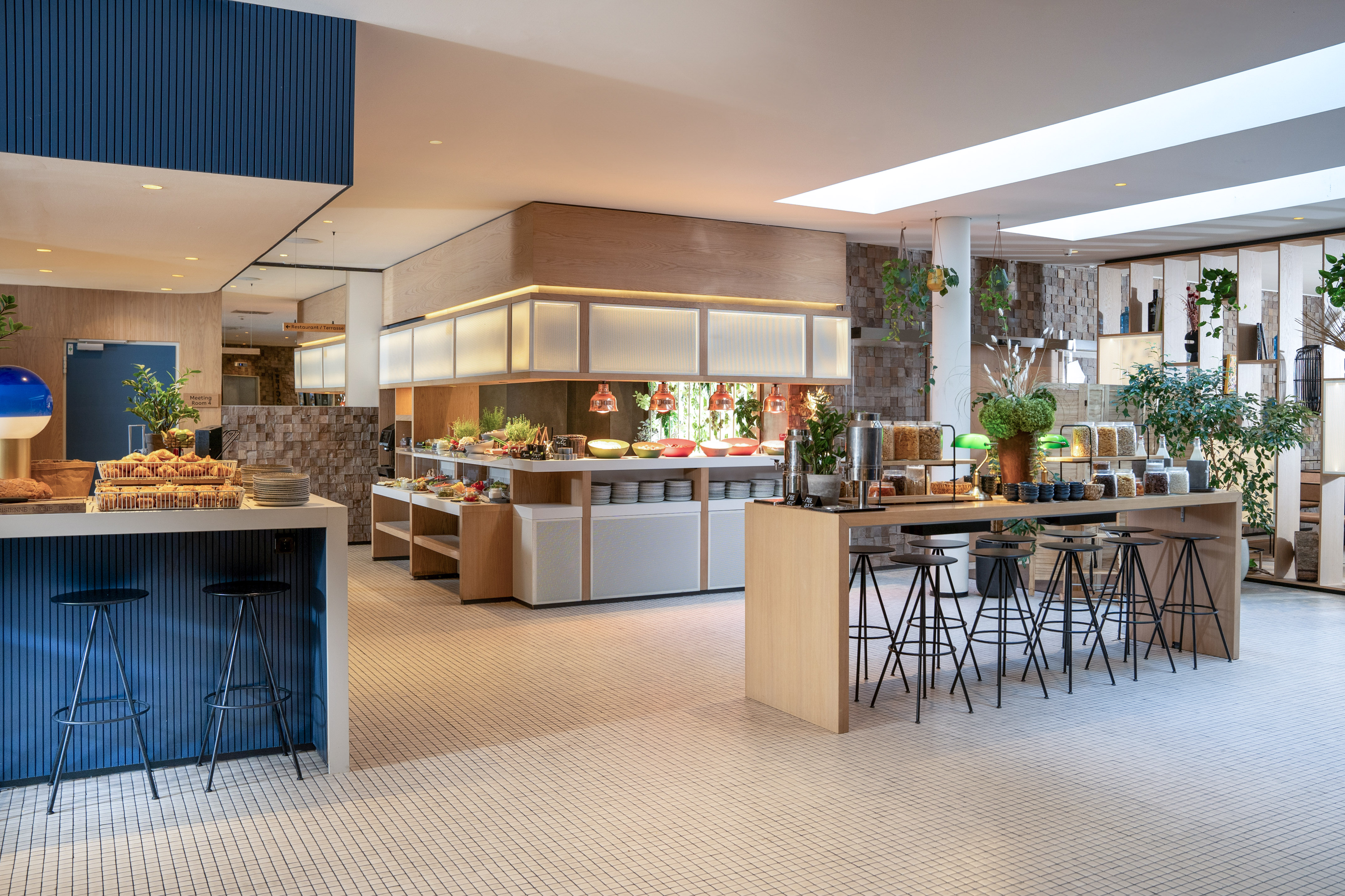 Stylish hotel breakfast buffet featuring diverse food stations and bar seating.