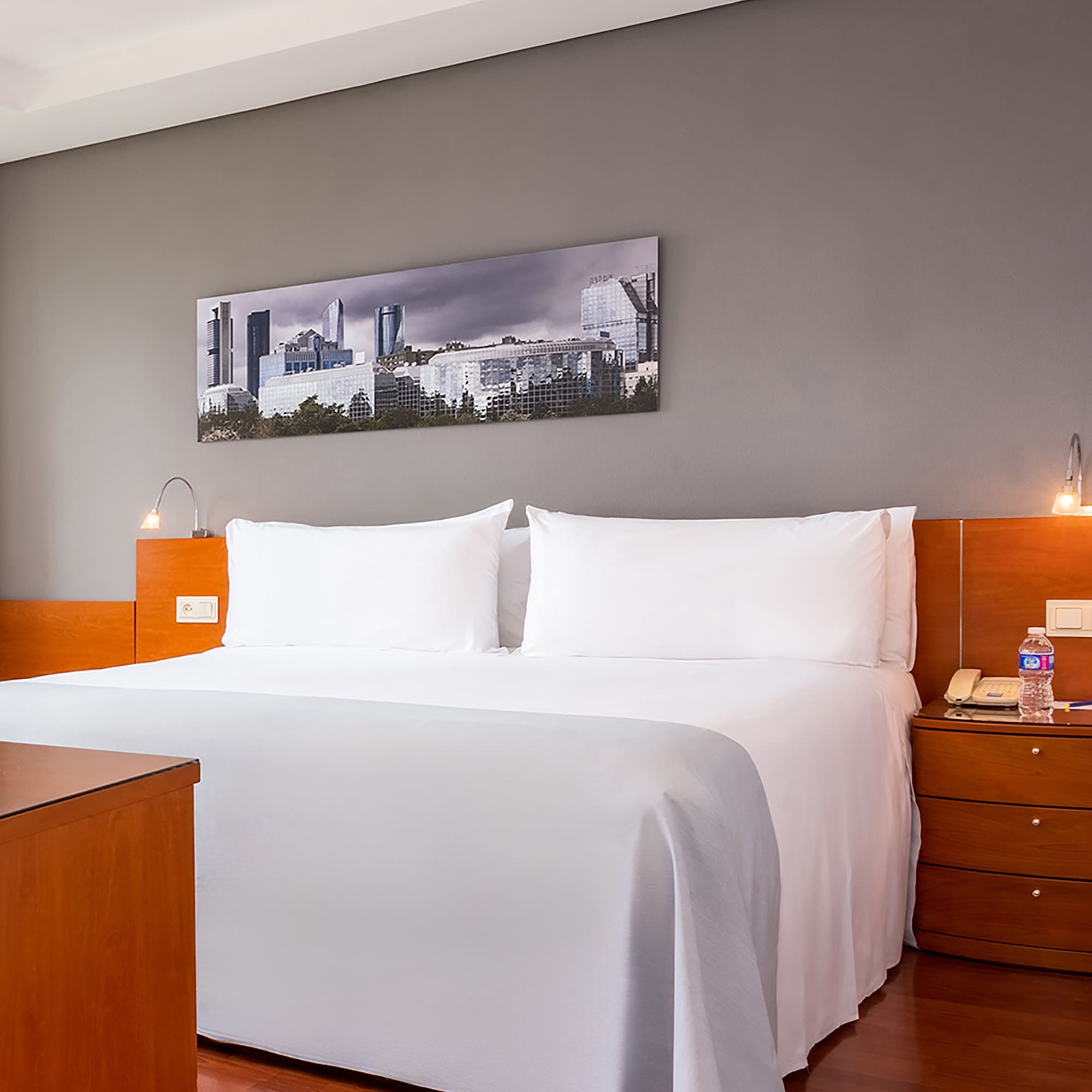 a bed with white sheets and a wood headboard