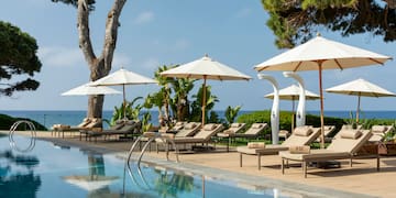 a pool with umbrellas and lounge chairs