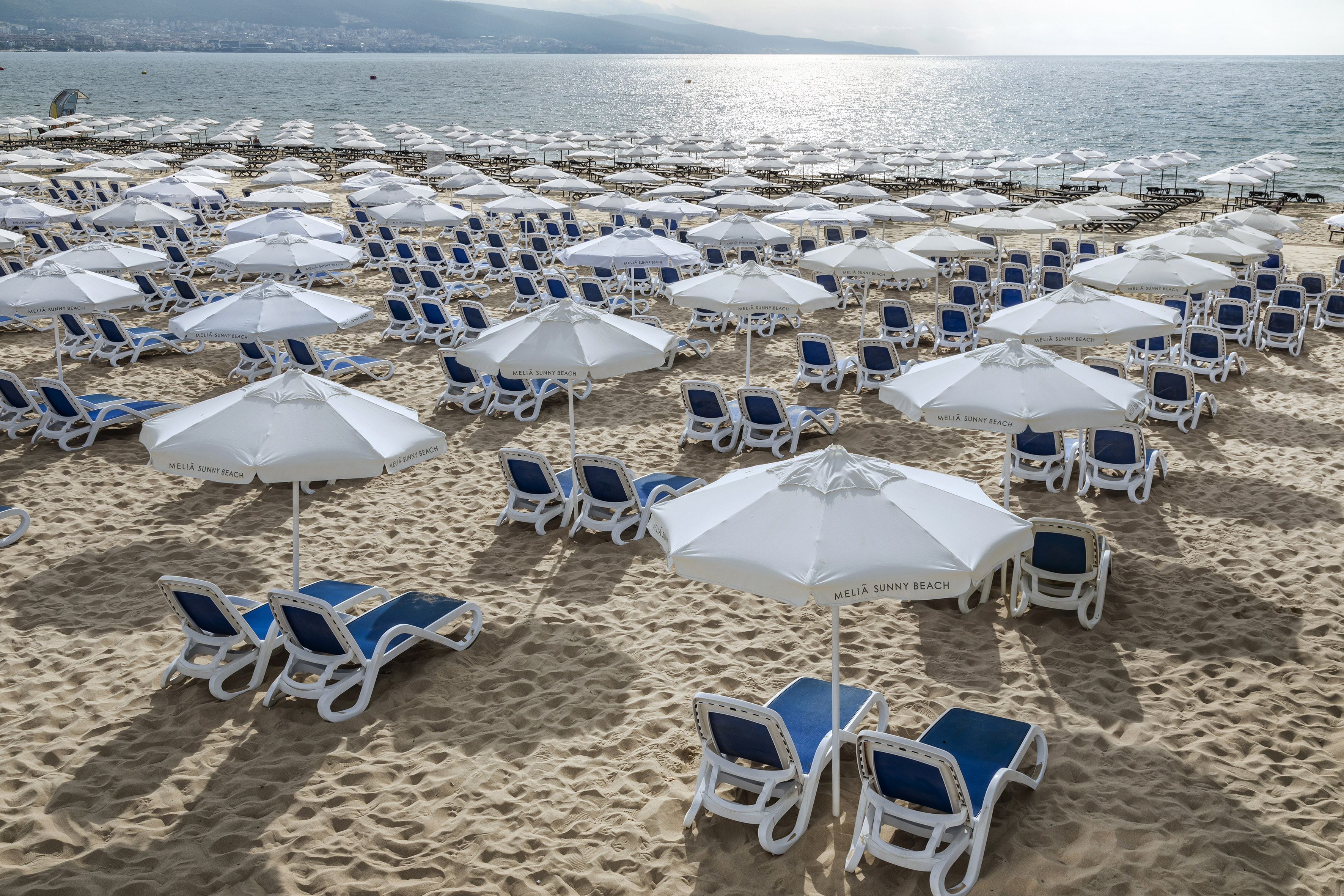 a beach with umbrellas and chairs