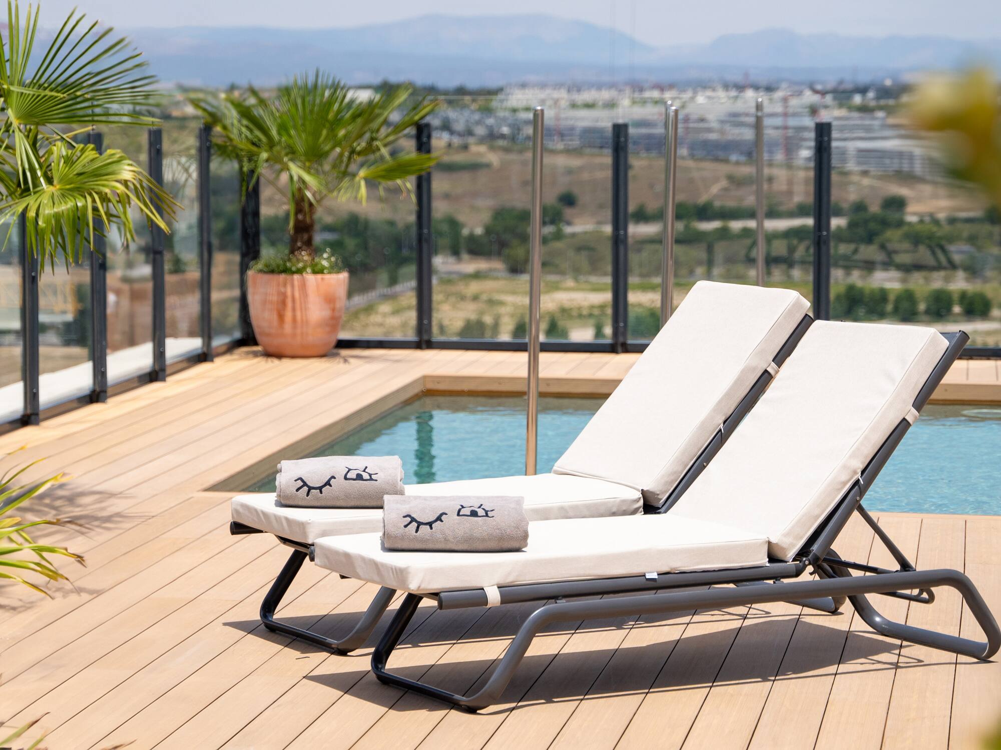 a deck with chairs and a pool