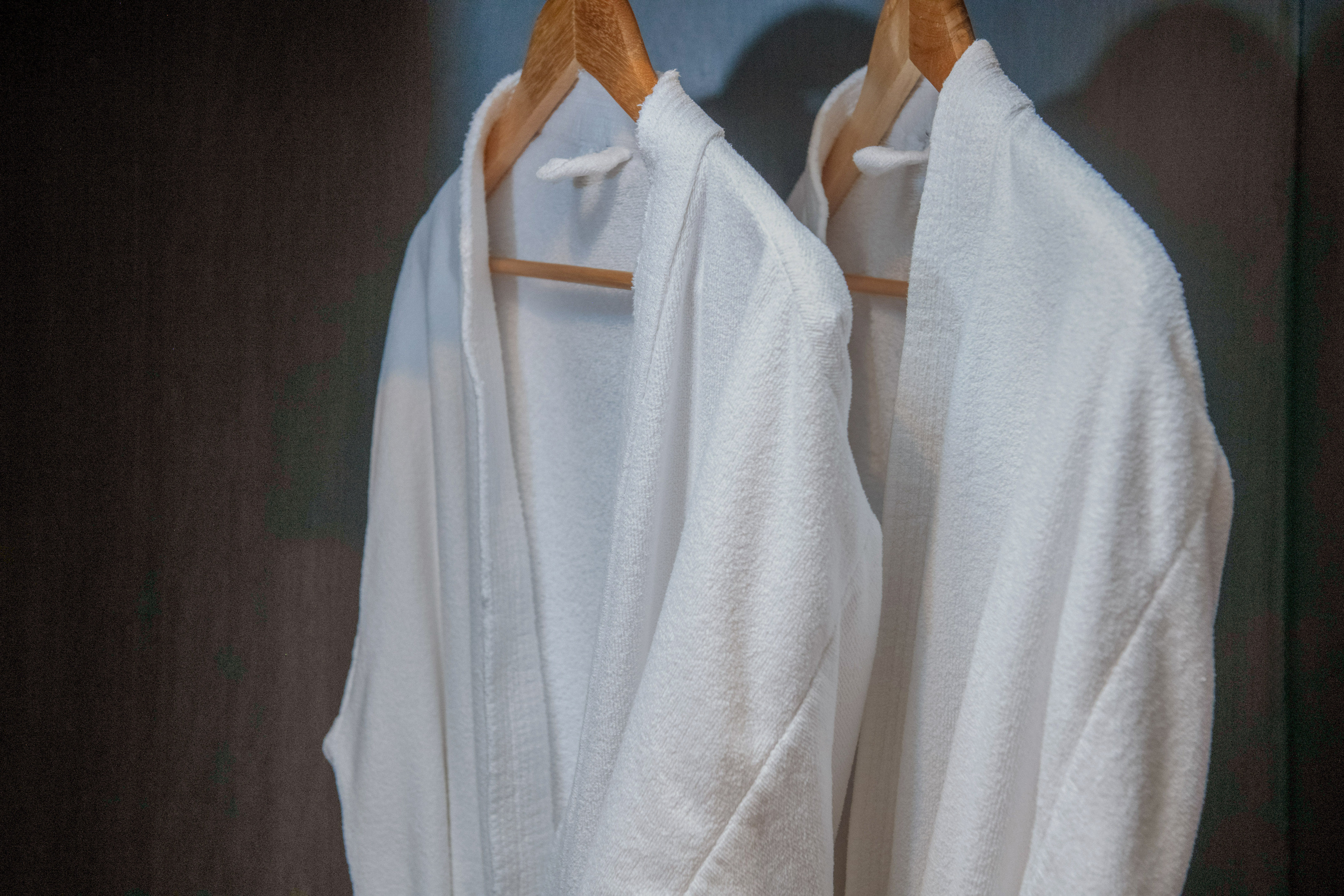 a pair of white bathrobes on a swinger
